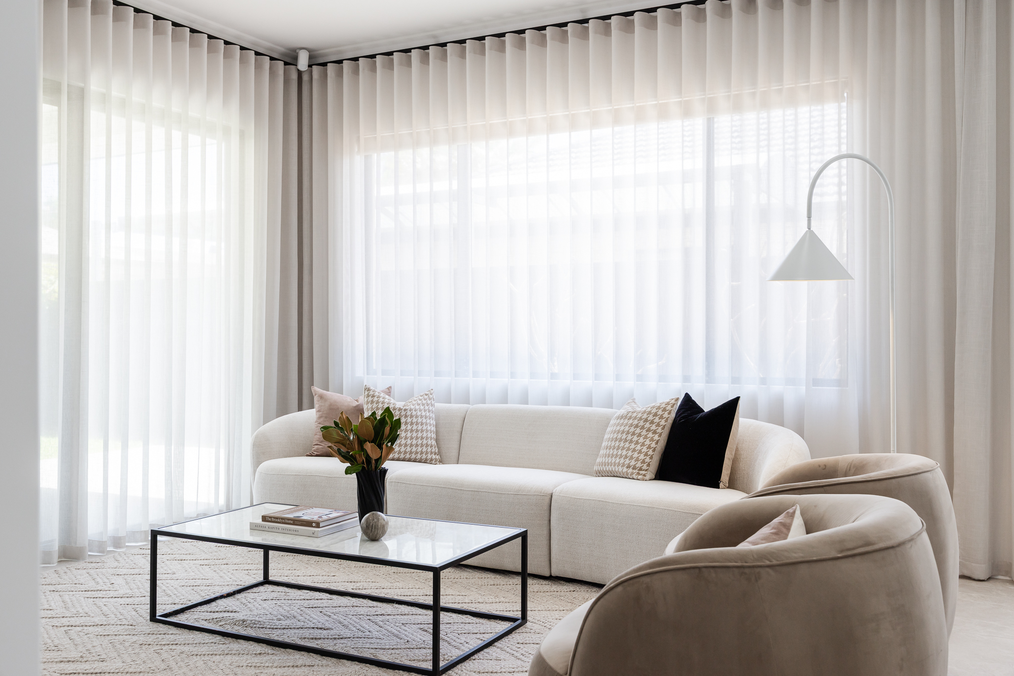 Styled living room with white sofa, sheer curtains and floor lamp