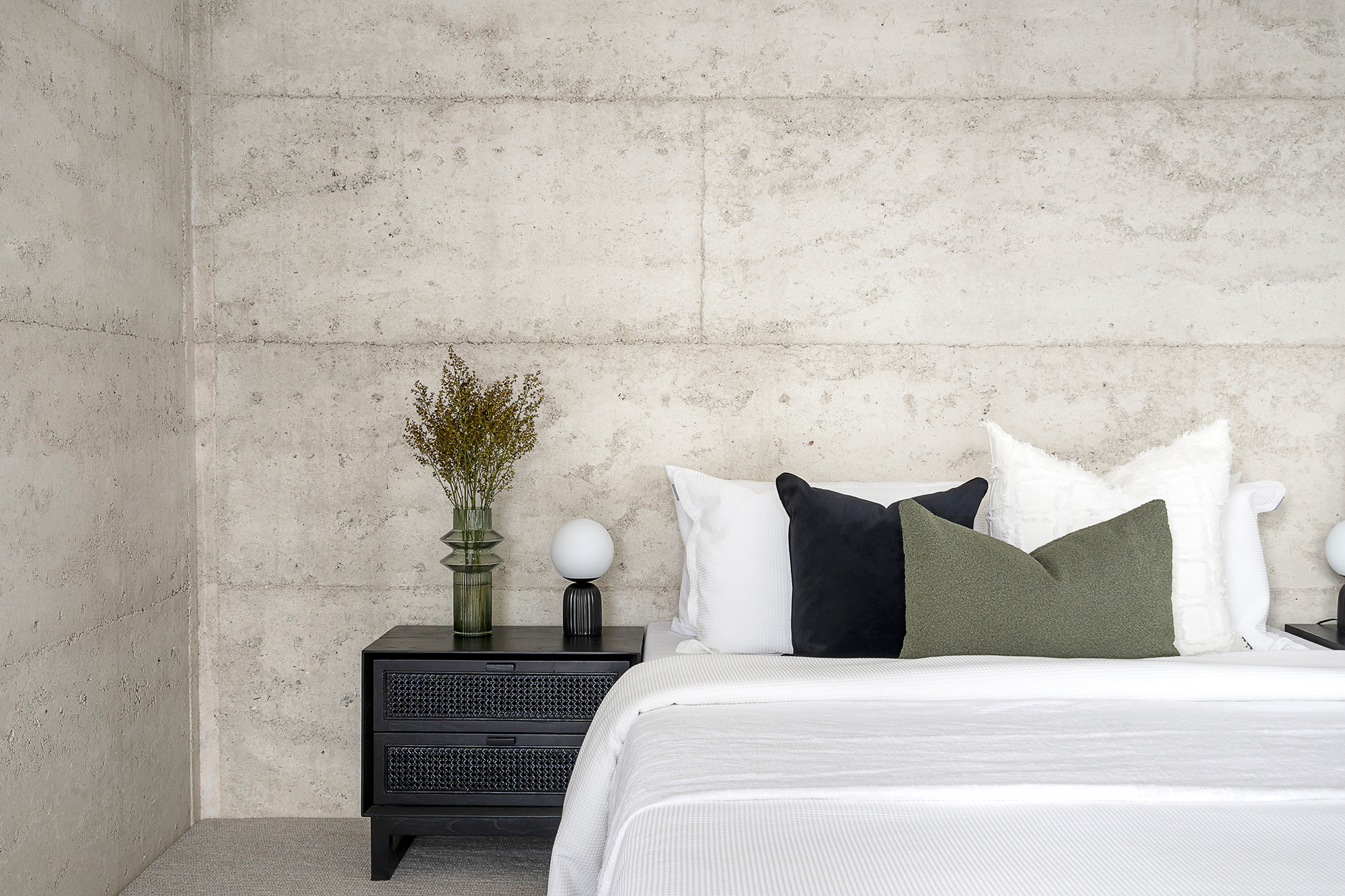 Styled bedroom with raw concrete feature wall