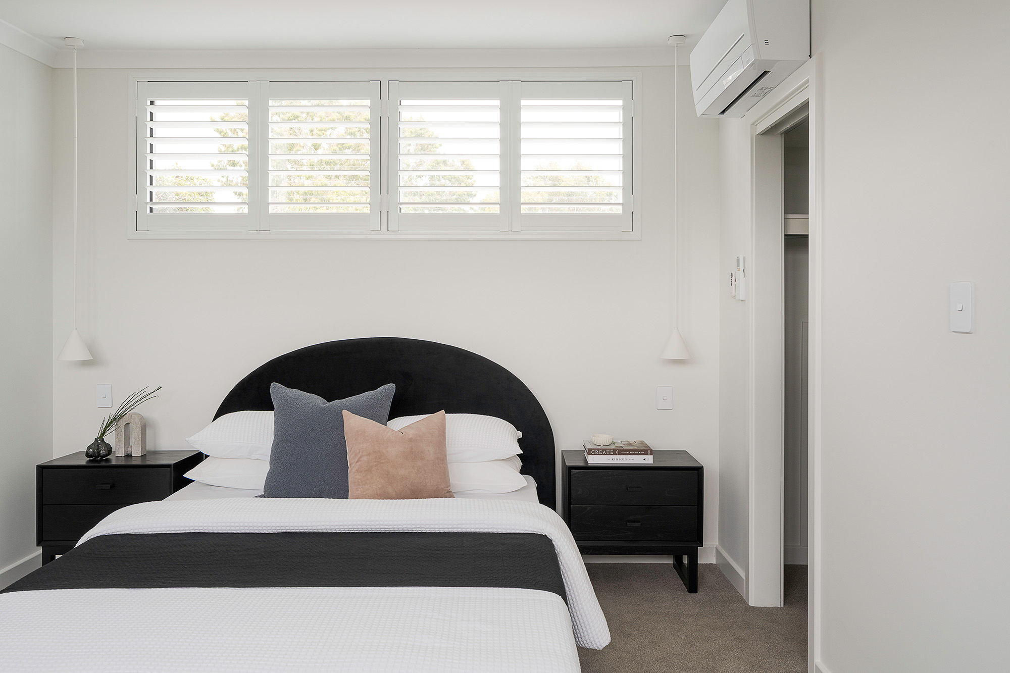 Styled bedroom with black curved headboard