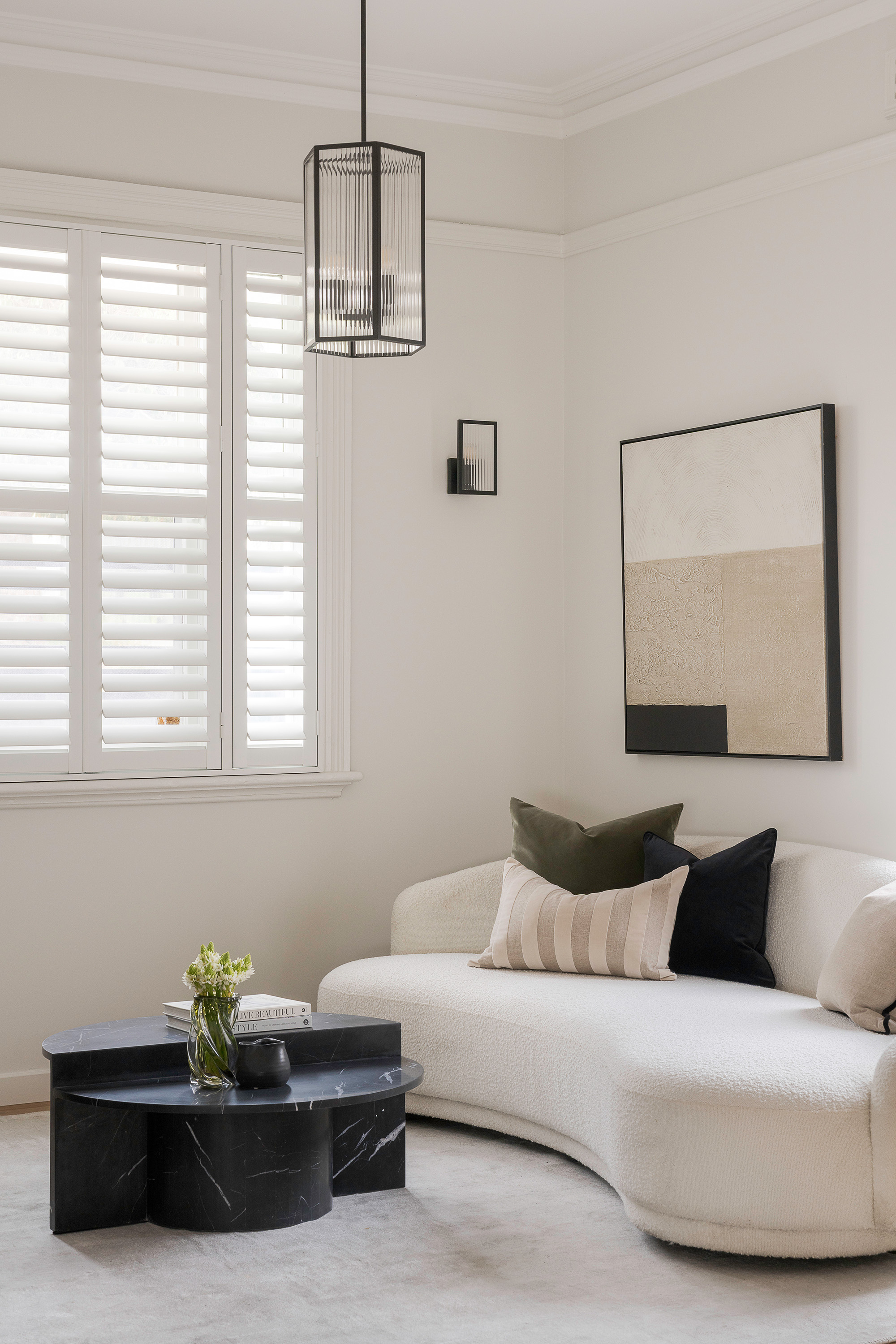 Living room styled with curved sofa and pendant light
