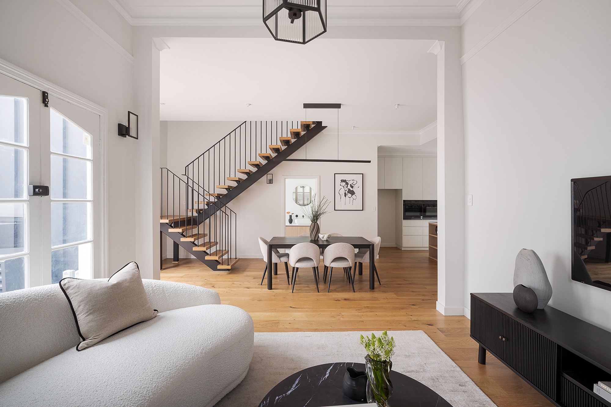 Living and dining area styled with staircase feature
