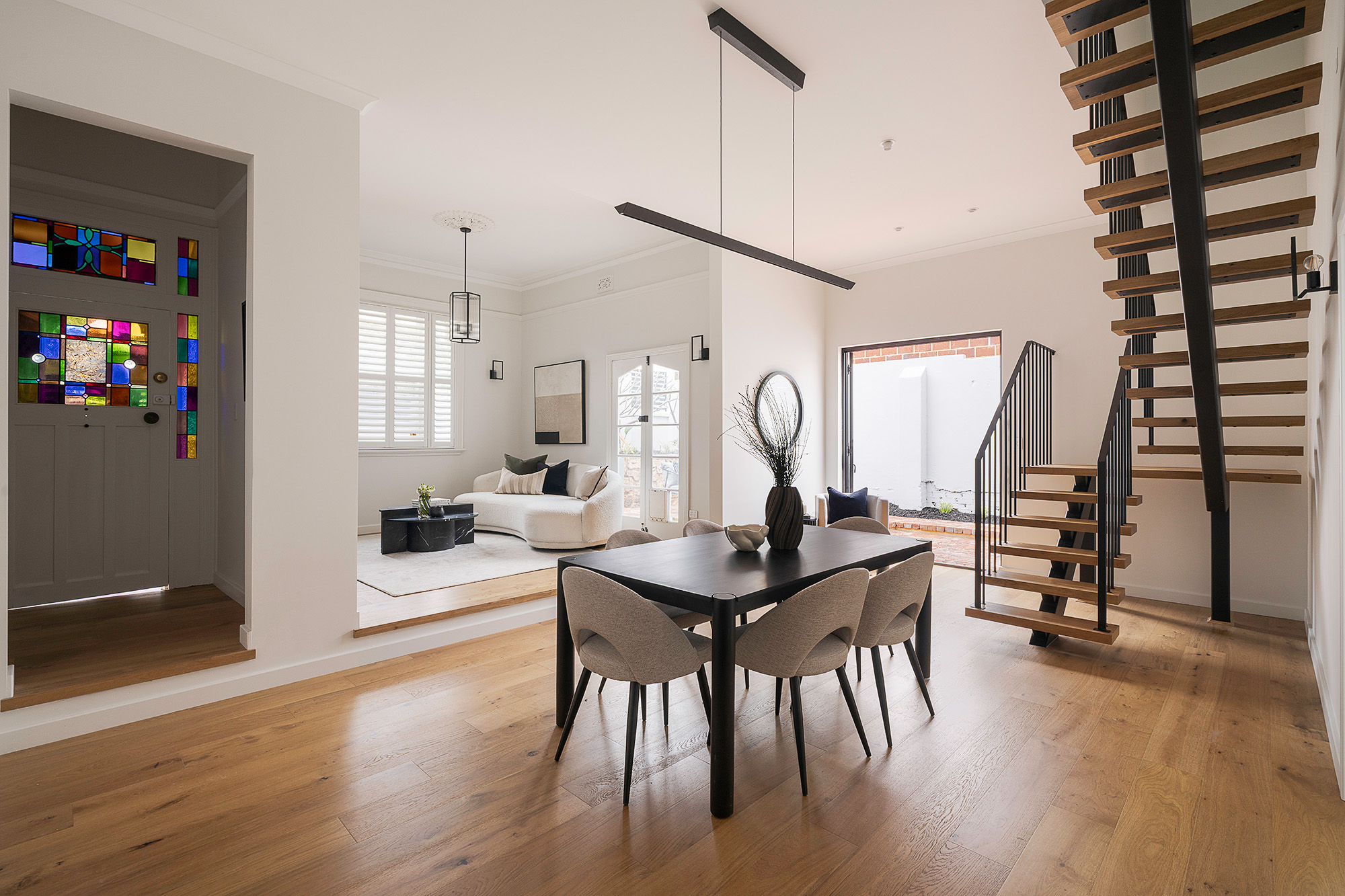 Dining area styled with pendant lighting and stained-glass feature