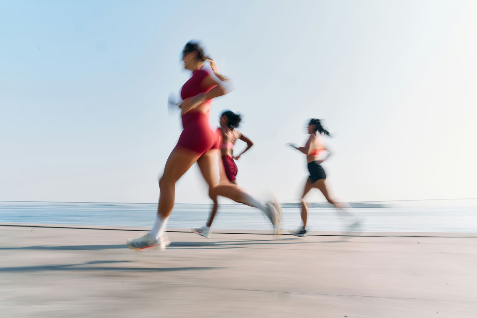 a group of women running on a beach