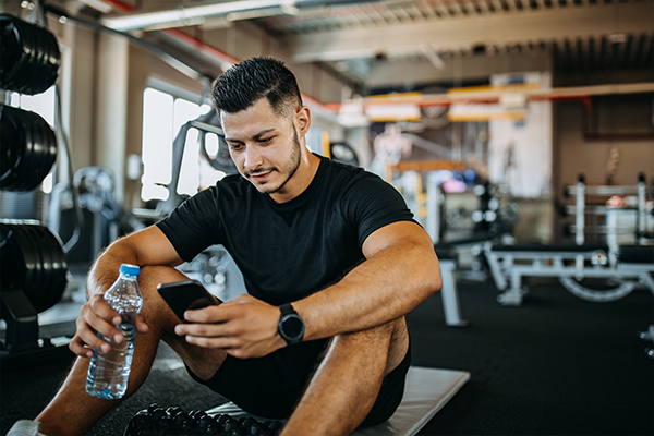 a man sitting on a mat looking at a phone