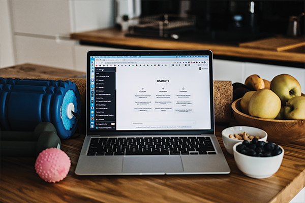 a laptop on a table with food and fruits
