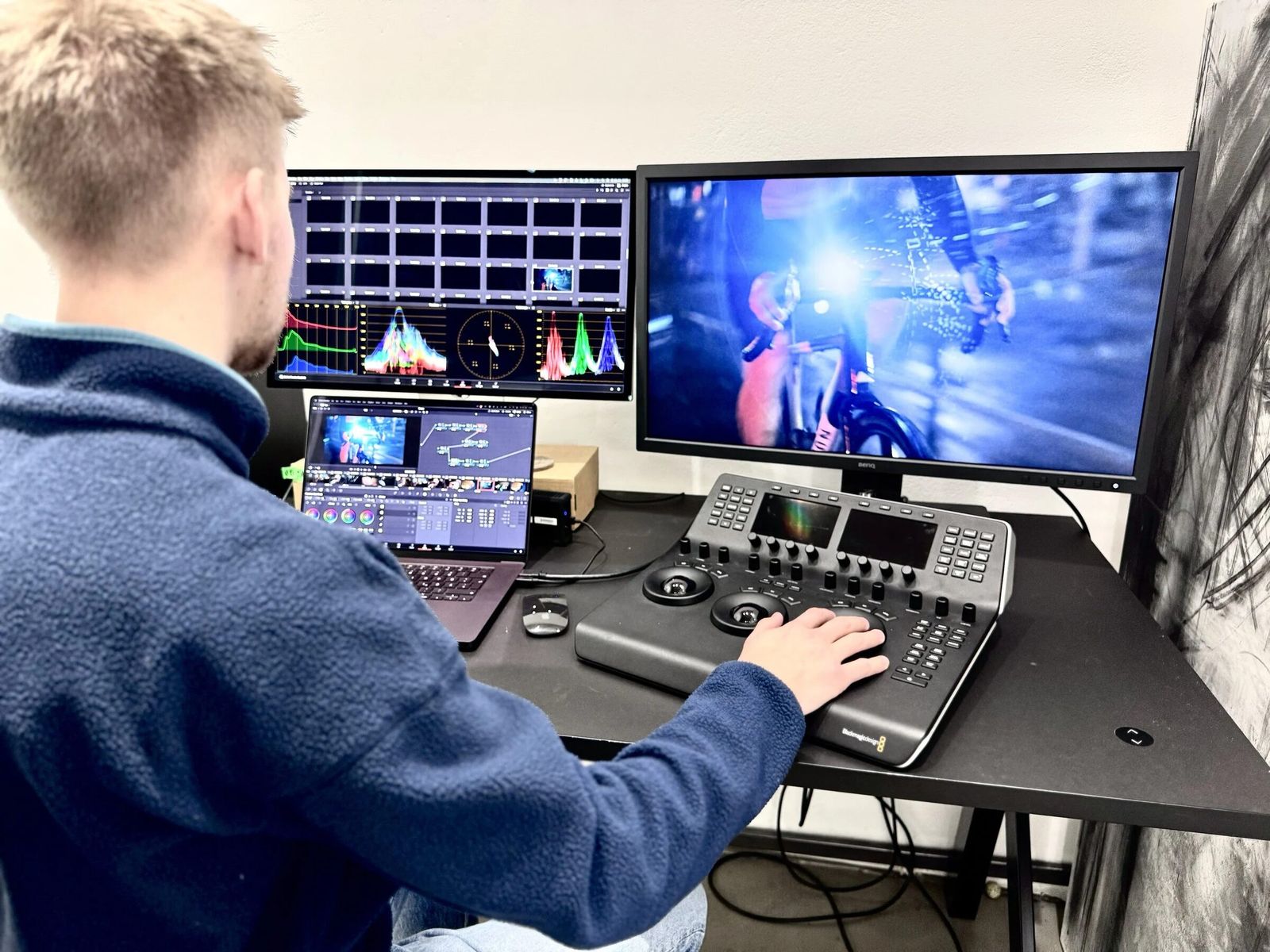 Colorist am Grading-Panel vor Waveform-Monitor und Vorschaubild