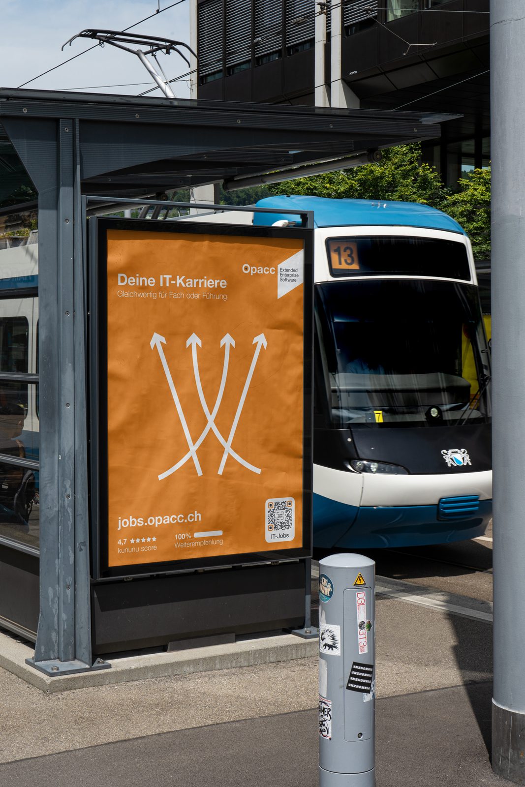 F200-Plakat der Opacc Kampagne an einer Tramhaltestelle, im Hintergrund ein einfahrendes Tram.