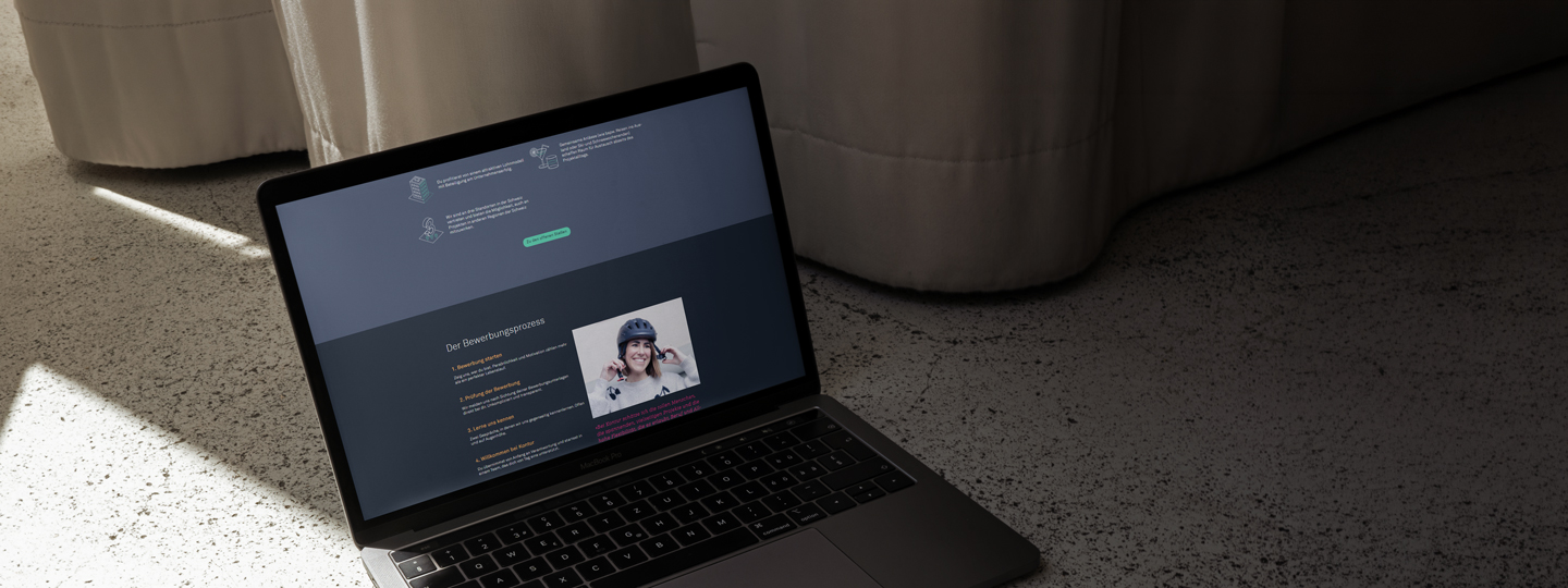 Laptop mit der neuen Kontur Karriereseite, Abschnitt Bewerbungsprozess in vier Schritten mit Mitarbeitendenporträt.