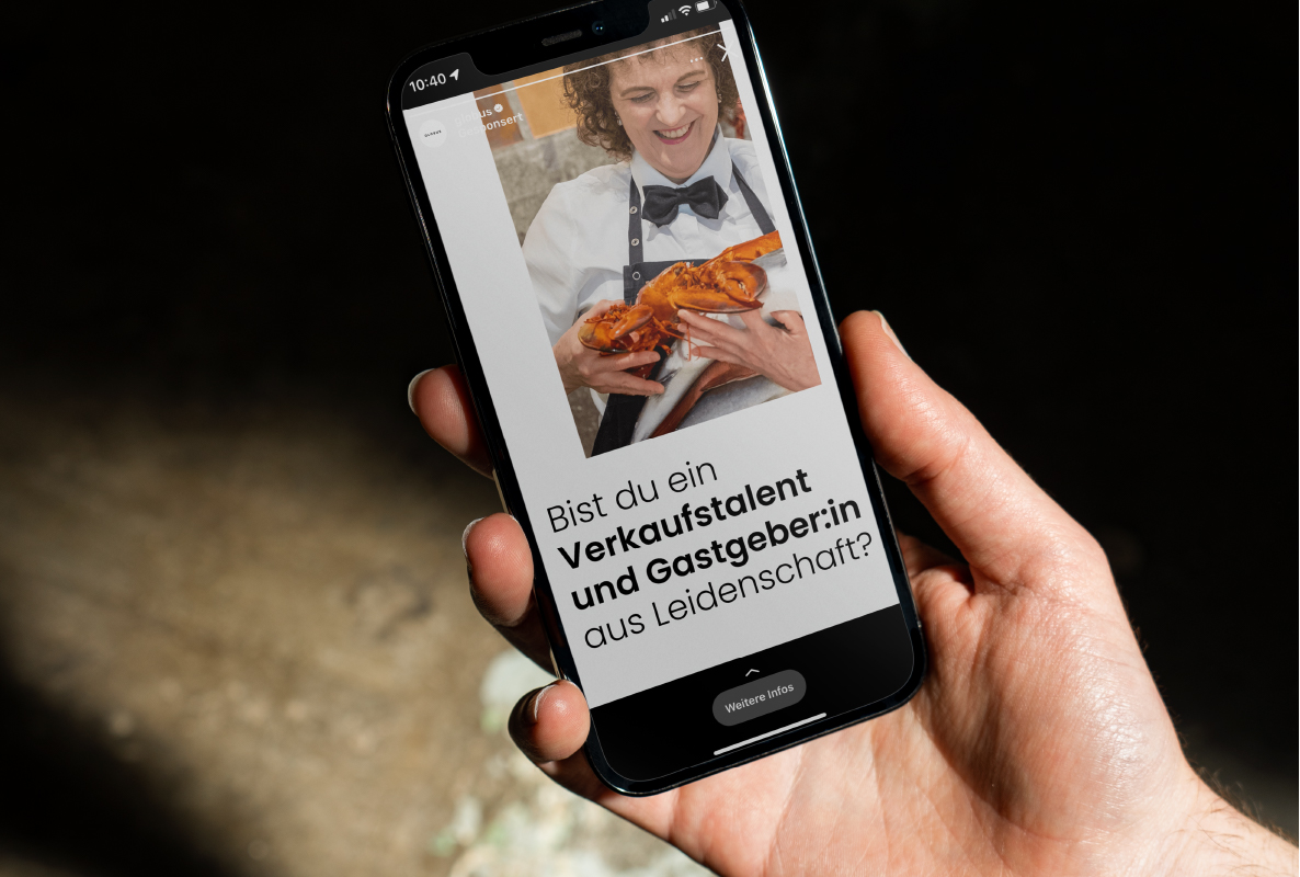 Hand hält ein Smartphone mit einer Globus Story-Ad: Bist du ein Verkaufstalent und Gastgeber:in aus Leidenschaft?