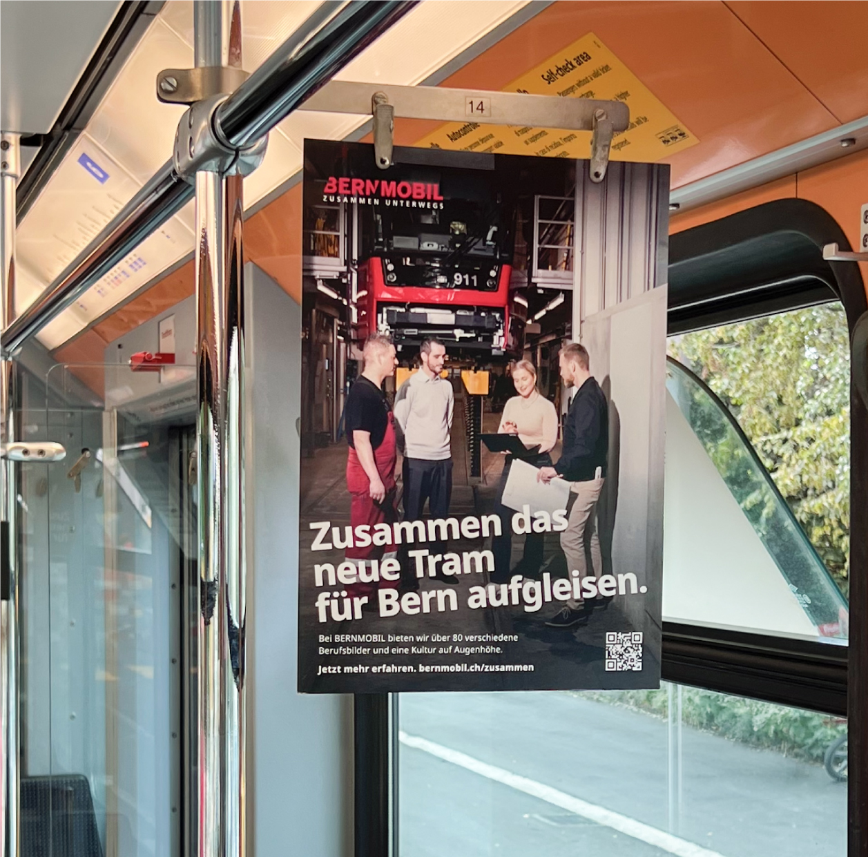 Aushang der BERNMOBIL Kampagne im Innenraum eines Fahrzeugs: Zusammen das neue Tram für Bern aufgleisen.