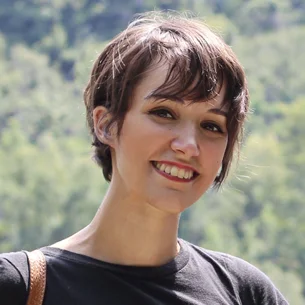 Portrait of Alexandra Patrono-Smith, chief commercial officer at Intertradedocs, standing outdoors with blurred trees in the background.