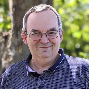 Portrait of Gary Smith, system administrator at Intertradedocs, standing outdoors with blurred trees in the background.