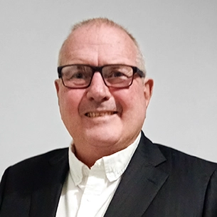 Portrait of Pierre De Villiers, head of sales and marketing at Intertradedocs, smiling in front of a plain grey background.