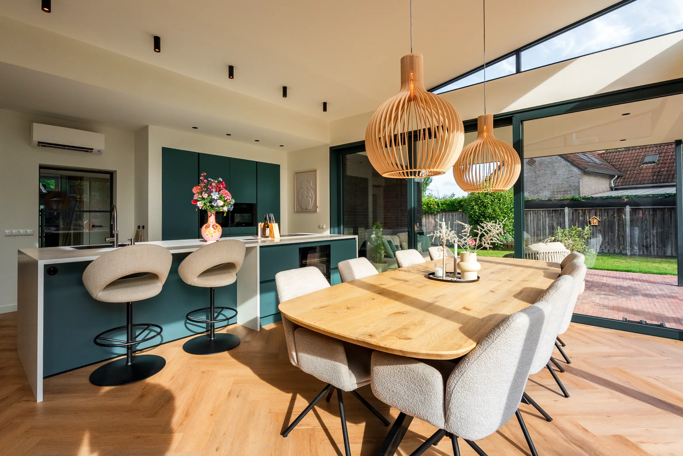 Keuken en eethoek in de aanbouw met zicht op de tuin door de schuifpui