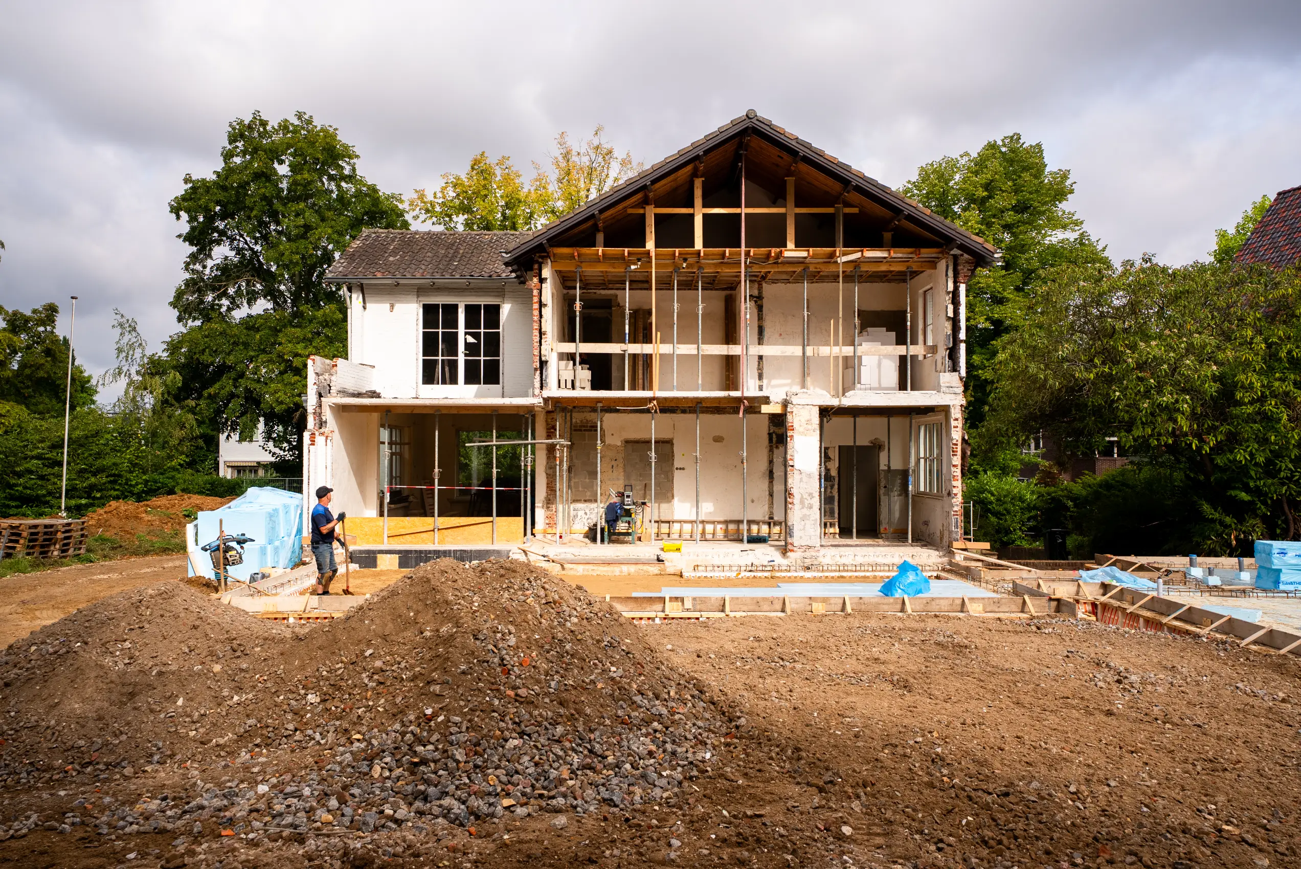 Achtergevel van de villa gestript over twee bouwlagen, met de houten kapconstructie in het zicht