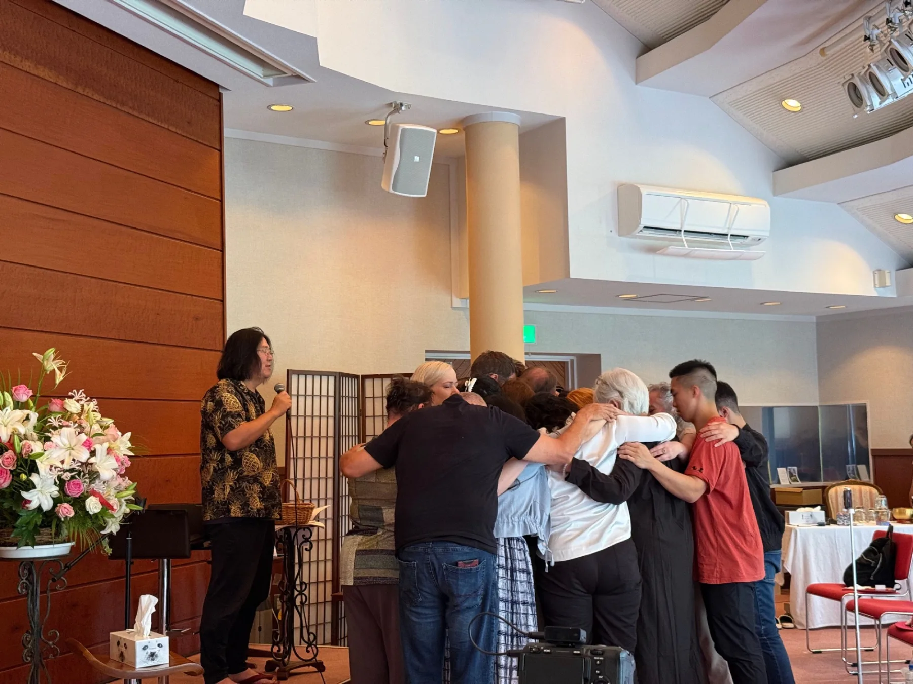 A circle of guests holding one another during the work