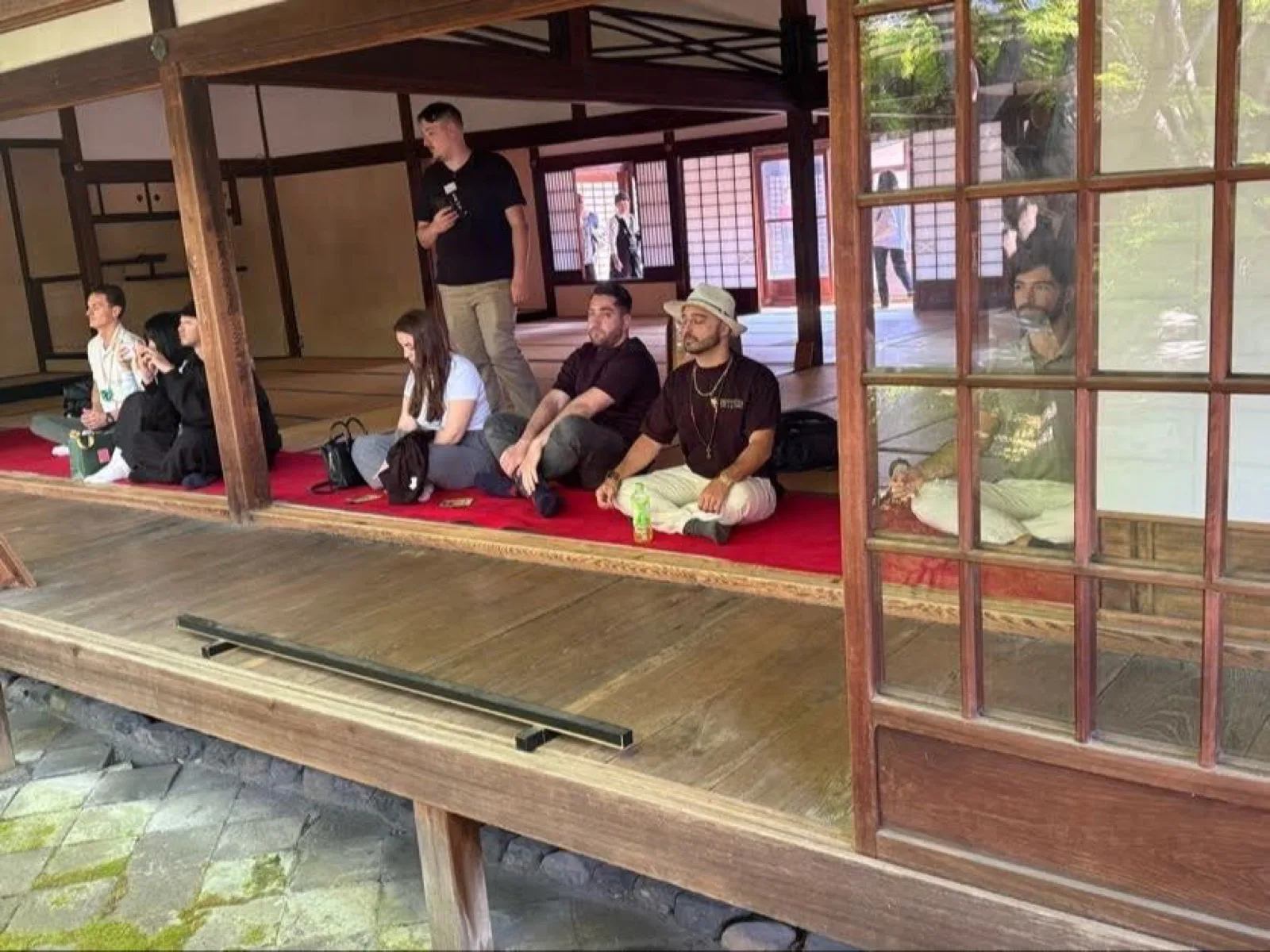 Retreat guests sitting together on a temple veranda in Japan