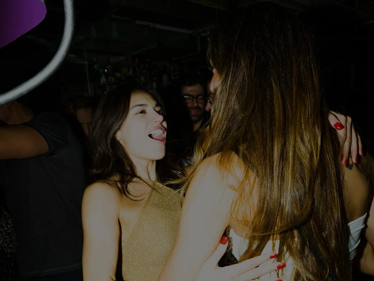 Two guests laughing together at a party at Le Bab
