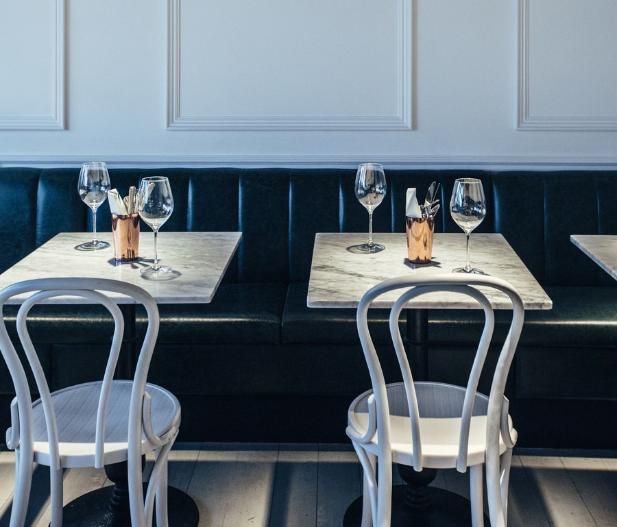 Le Bab Soho dining room with green banquettes, marble tables and bentwood chairs