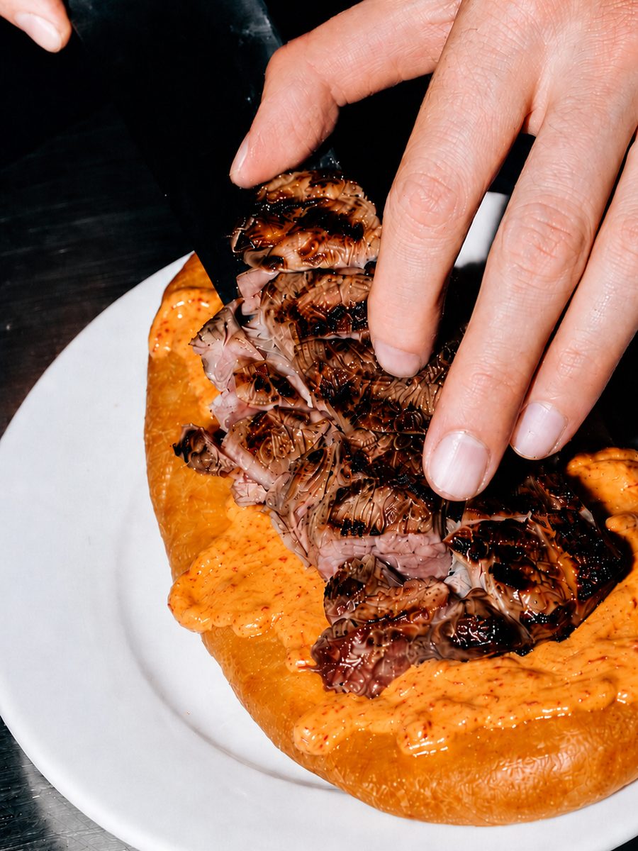 Sliced lamb steak on a flatbread with harissa labneh