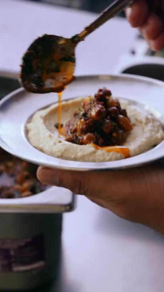 Spiced topping spooned over a bowl of hummus