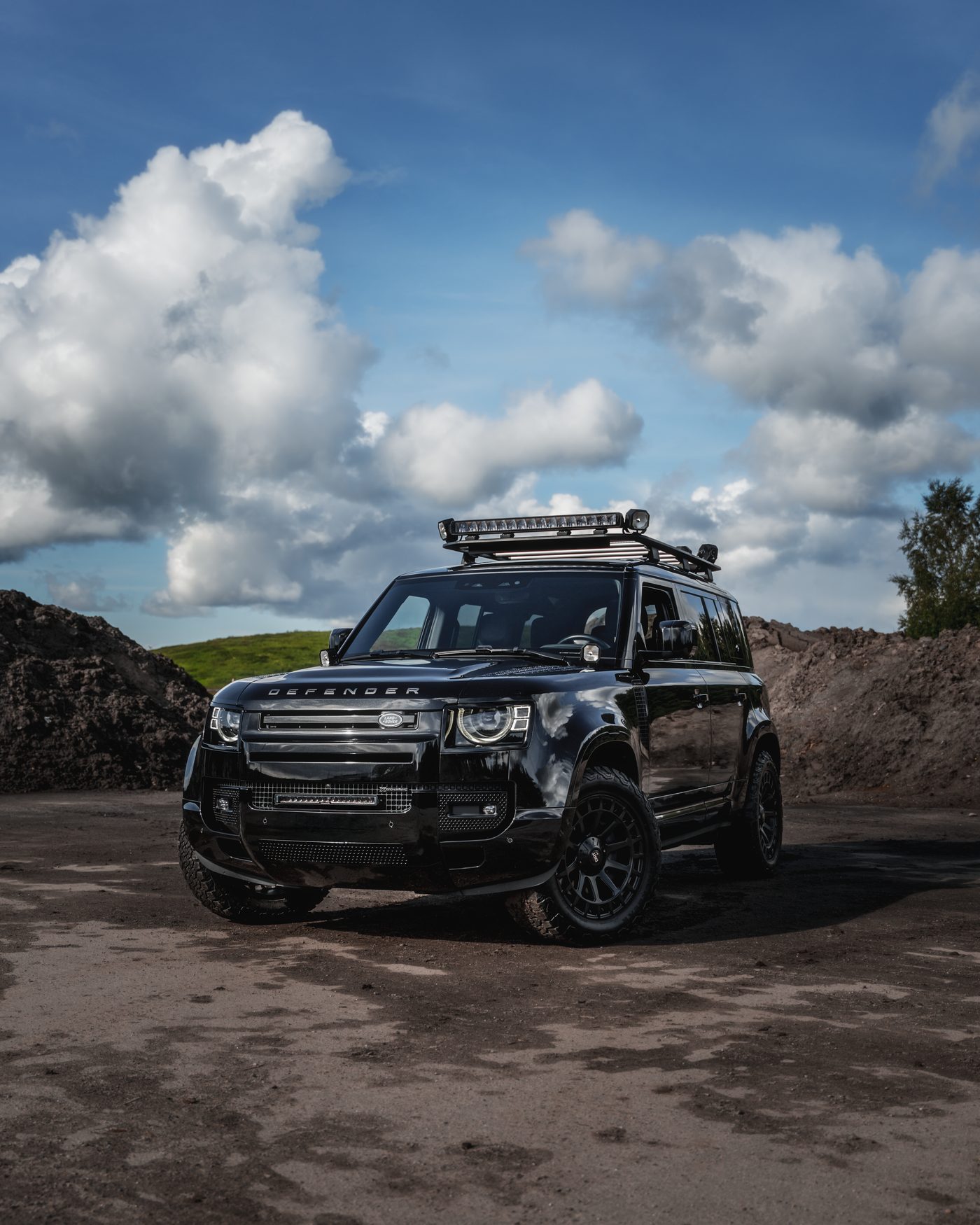 Land Rover Defender soratiellä dramaattisen pilvitaivaan alla