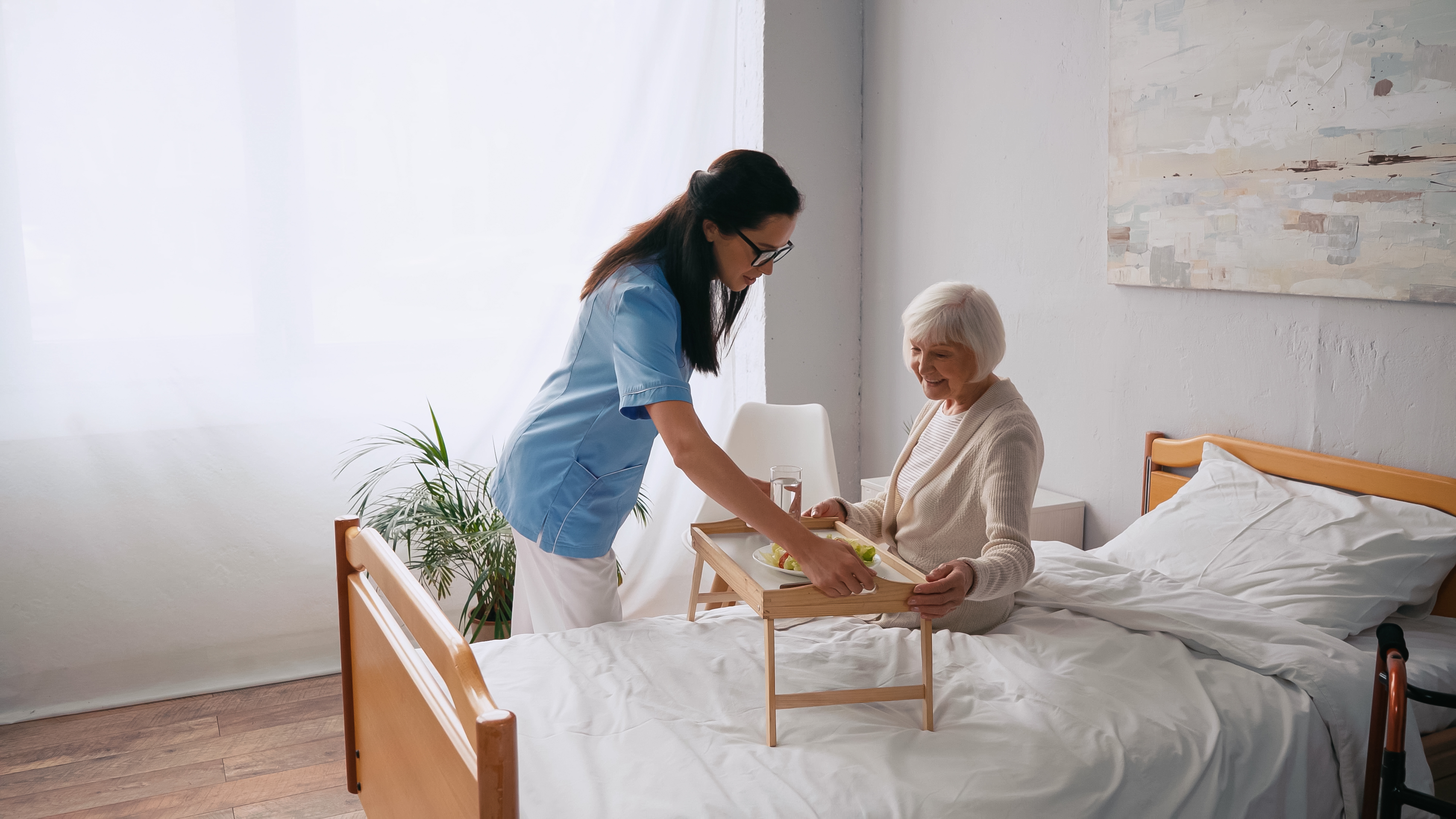 Level 3 Adult Care Worker caring for an elderly patient as part of their practical apprenticeship training.
