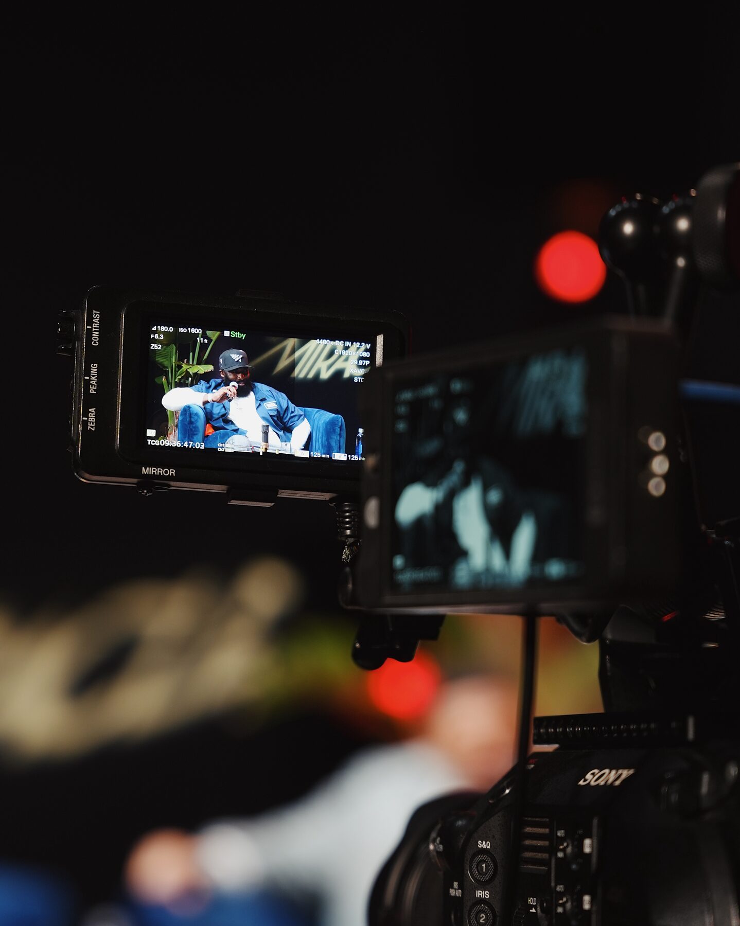 Broadcast camera framing the set from the control position