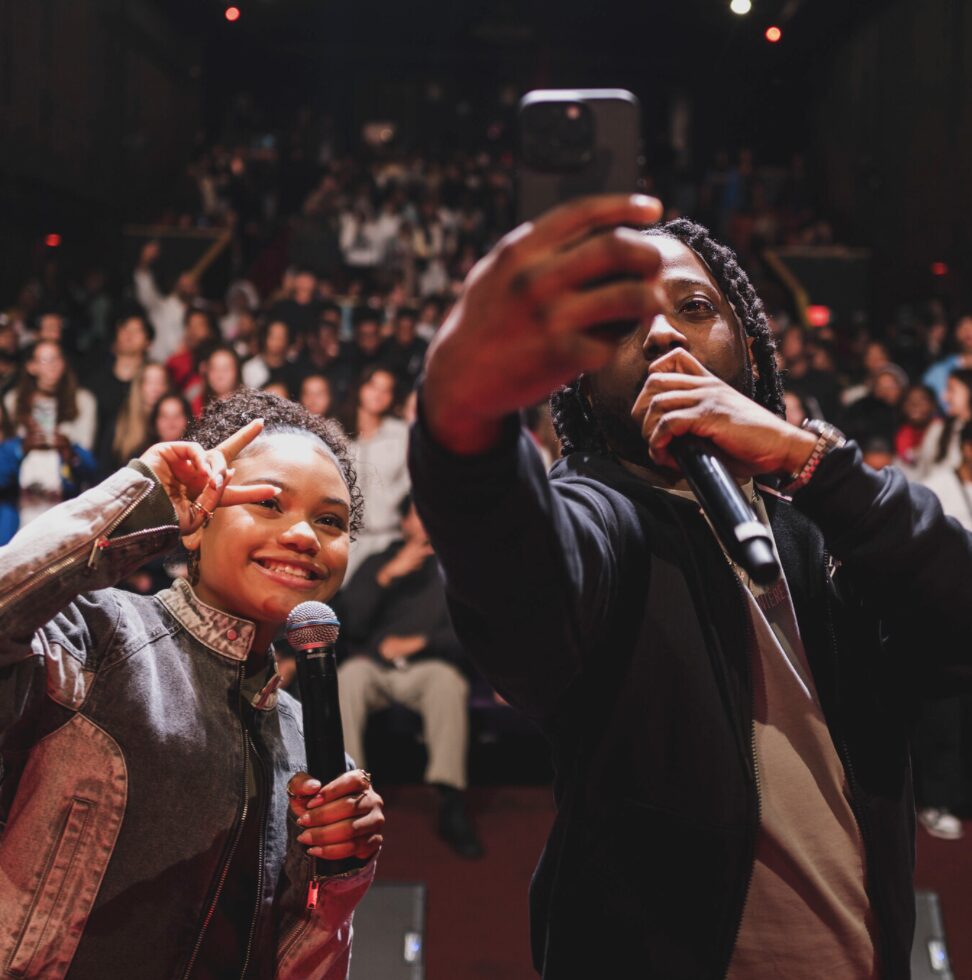 Host taking a selfie with the crowd from the stage