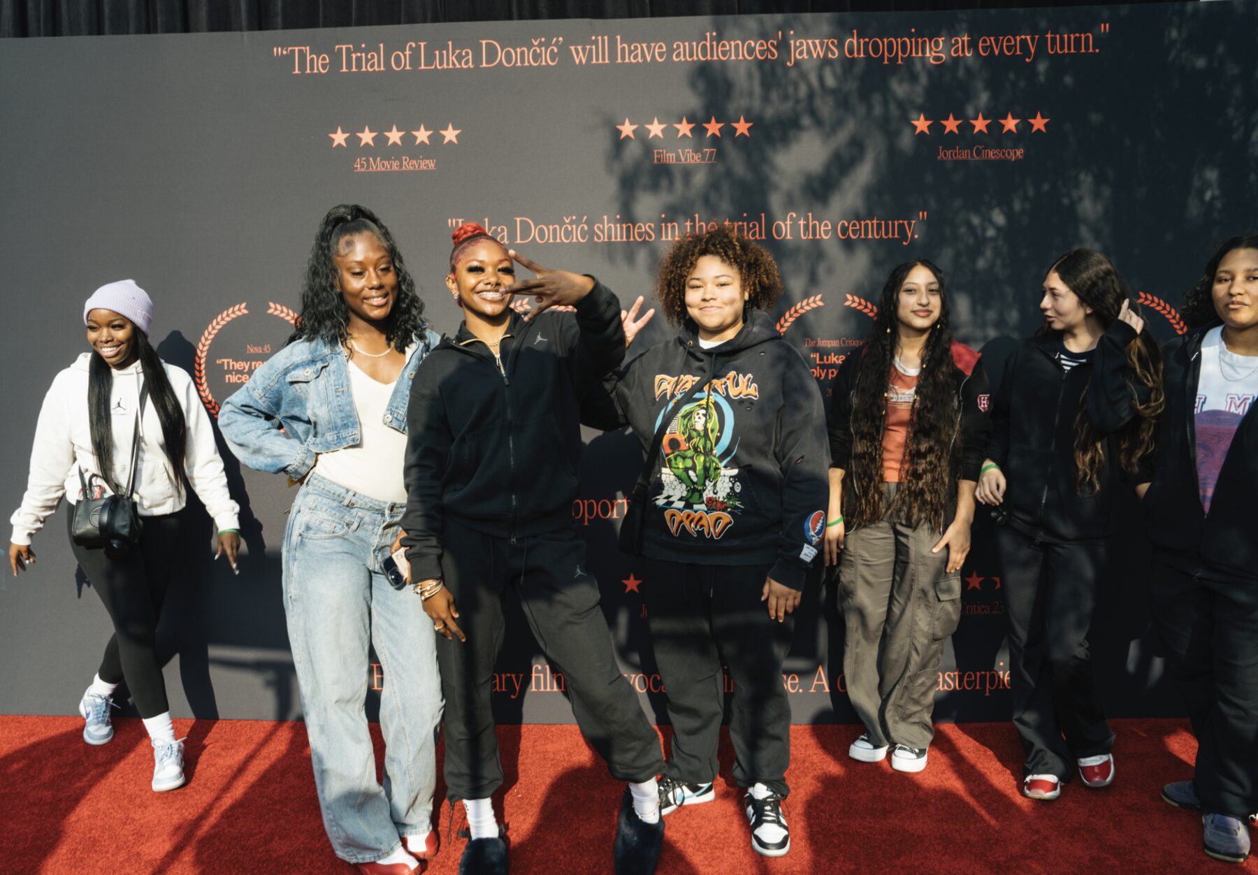 A team posing together on the red carpet
