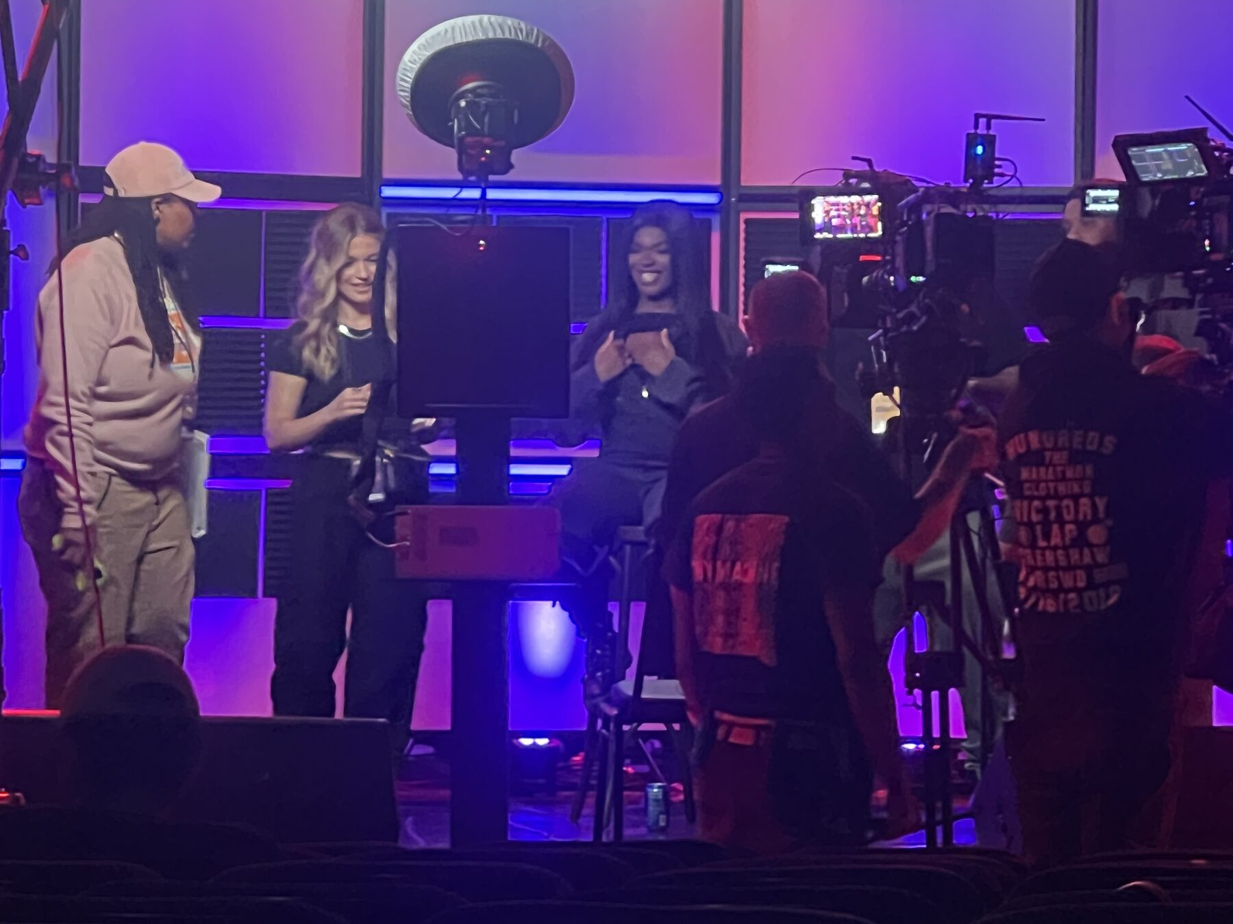 Hosts on the lit interior broadcast set