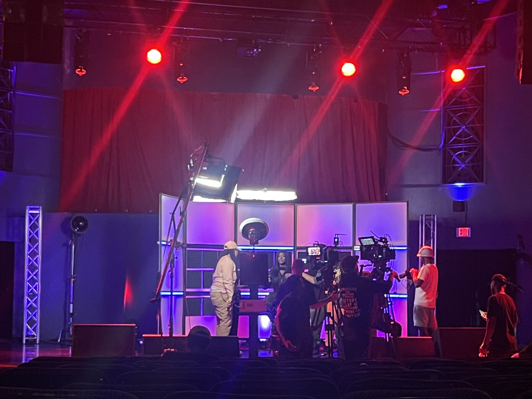 Studio set lit in red and purple with cameras