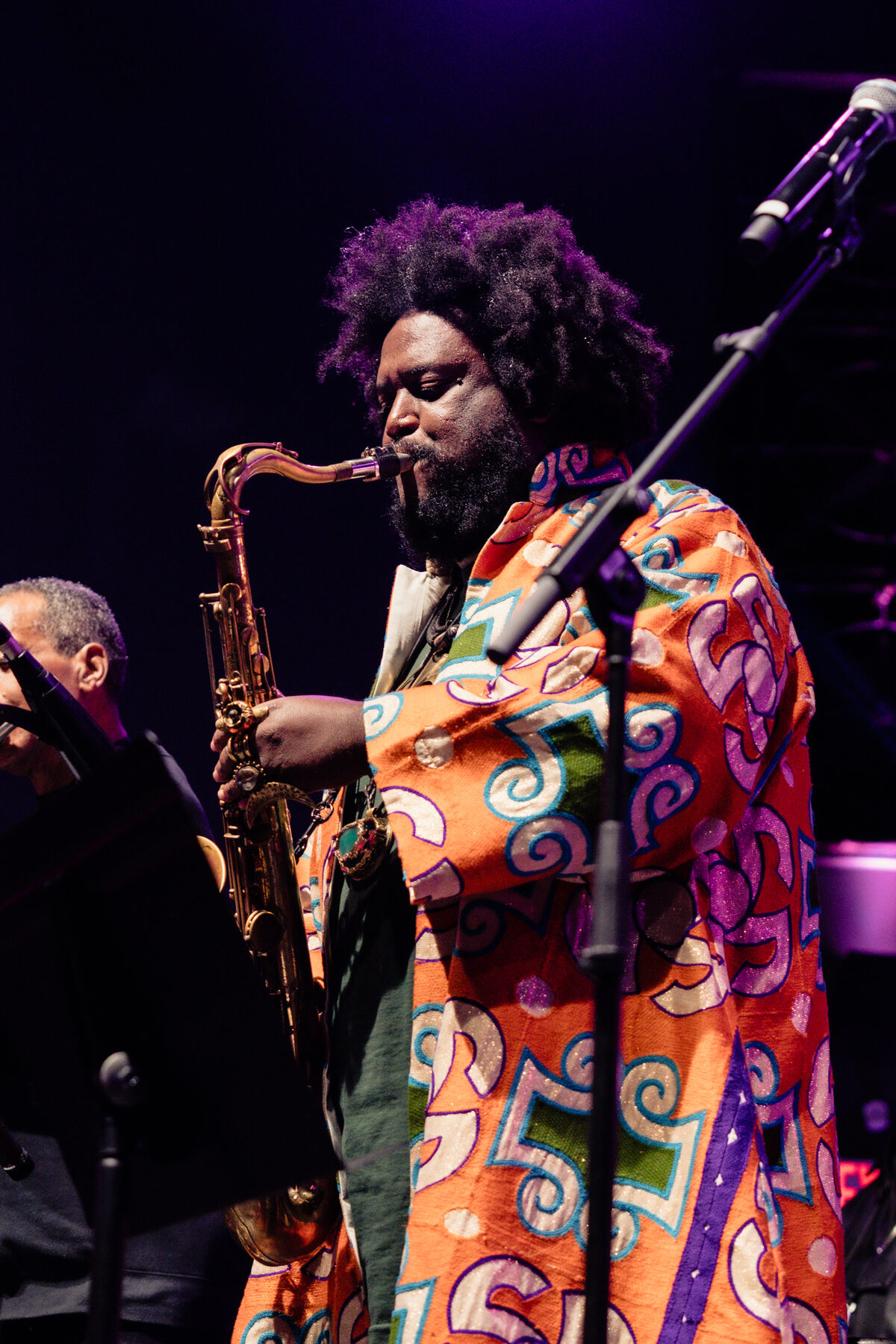 Kamasi Washington mid-solo under stage light