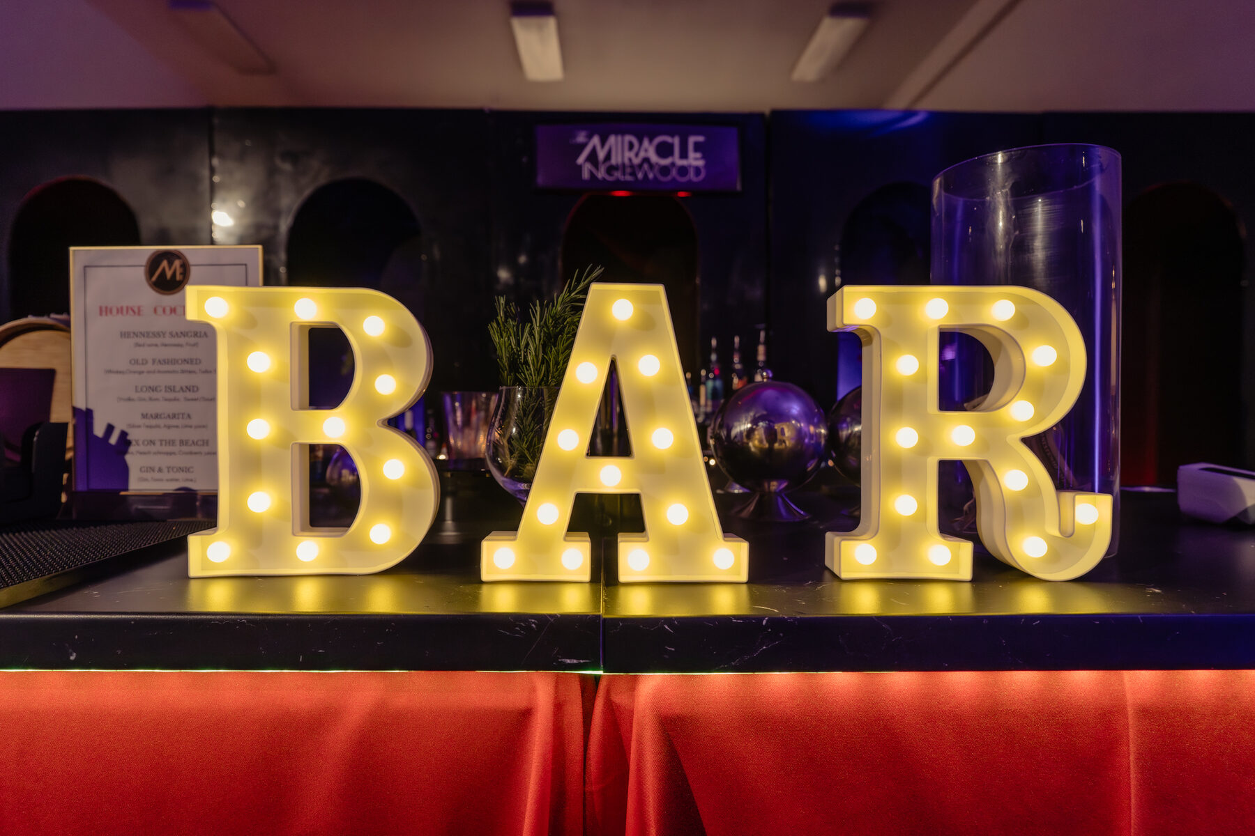 Marquee letters spelling BAR lit in the lounge