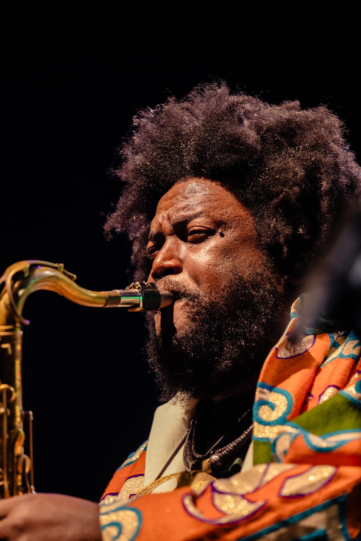 Kamasi Washington playing saxophone on the main stage at the fire relief concert
