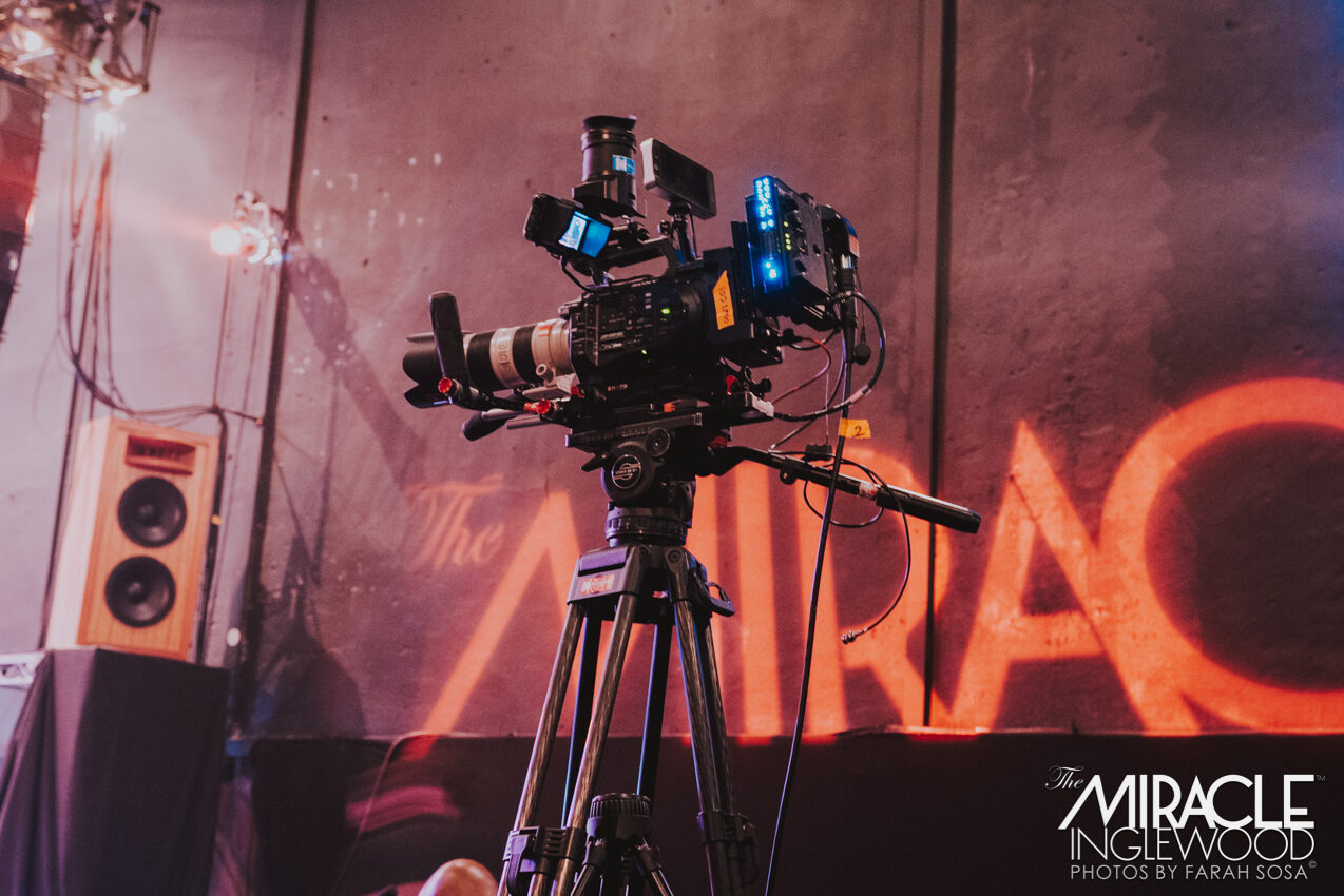 Cinema camera set up in front of a Miracle backdrop