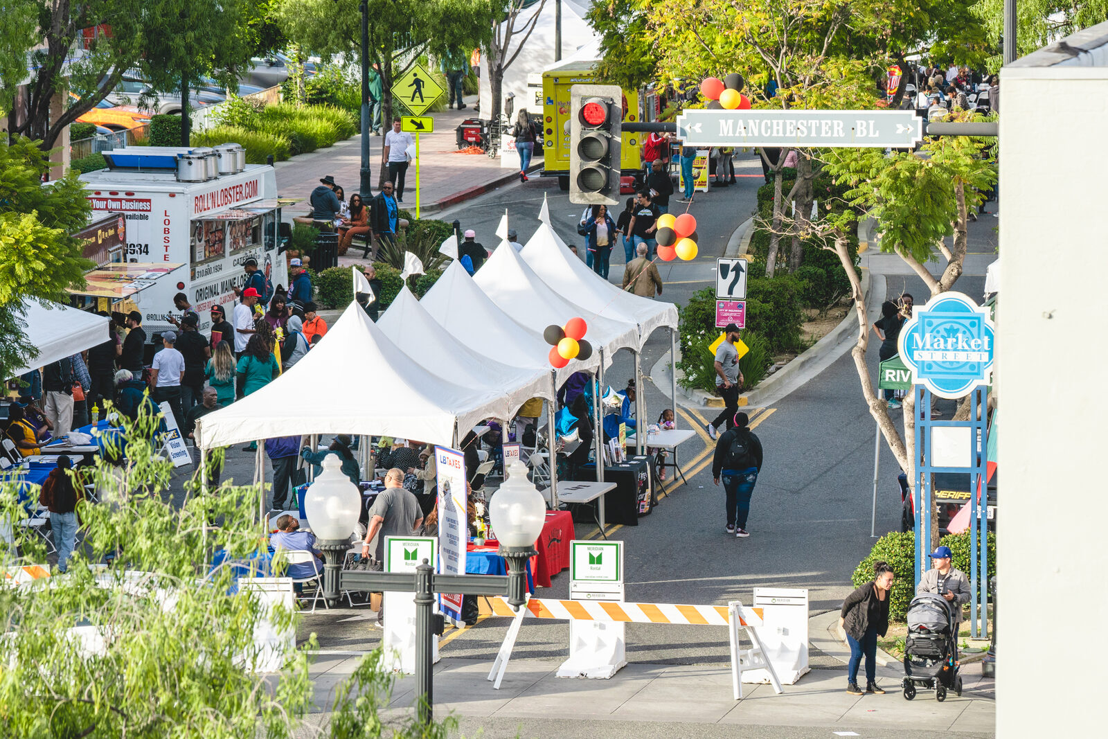 Street festival with tents and food vendors on the block