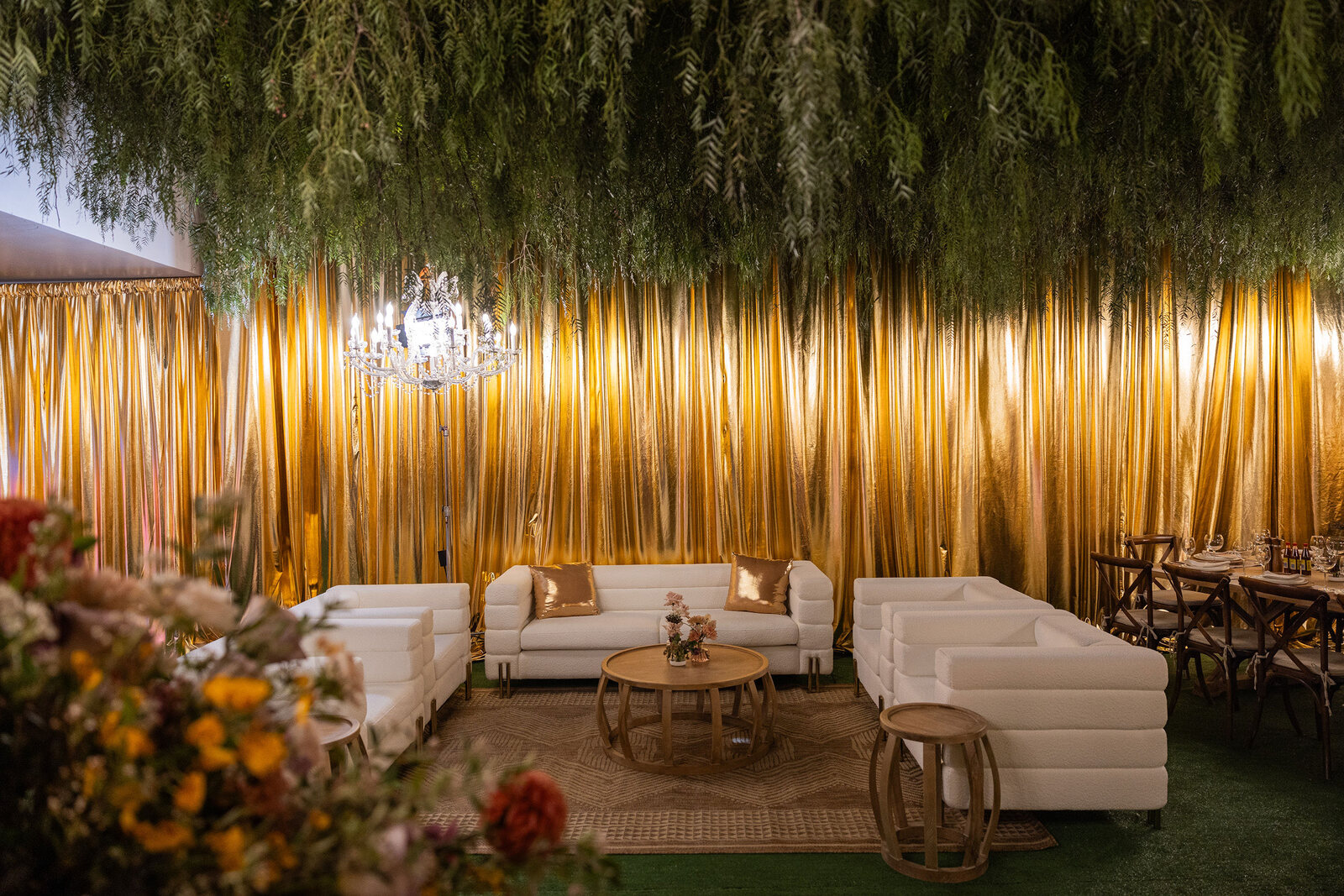 White lounge seating and floral arrangements in The Wing during a gala build-out