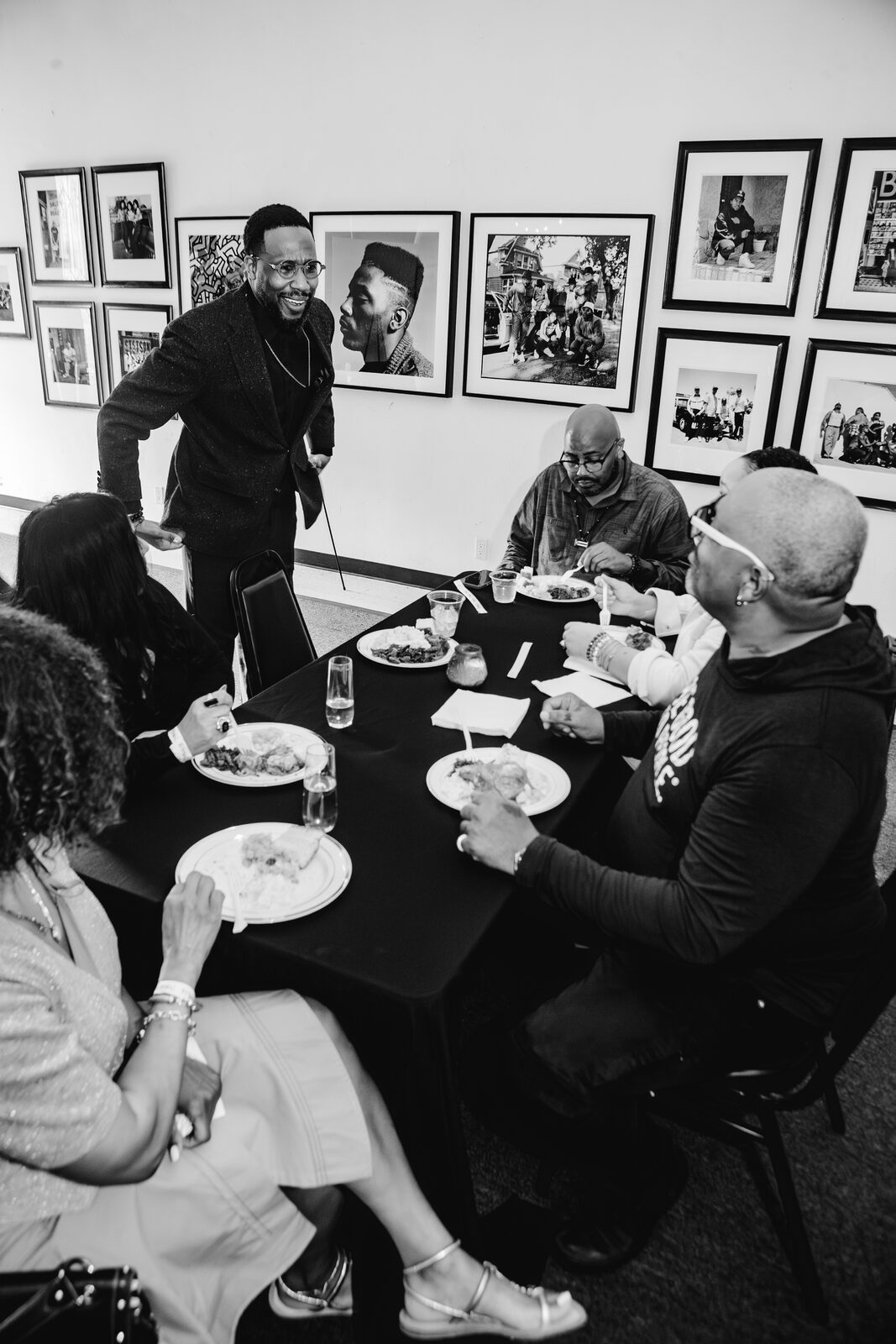 Community dinner at a long table in the gallery