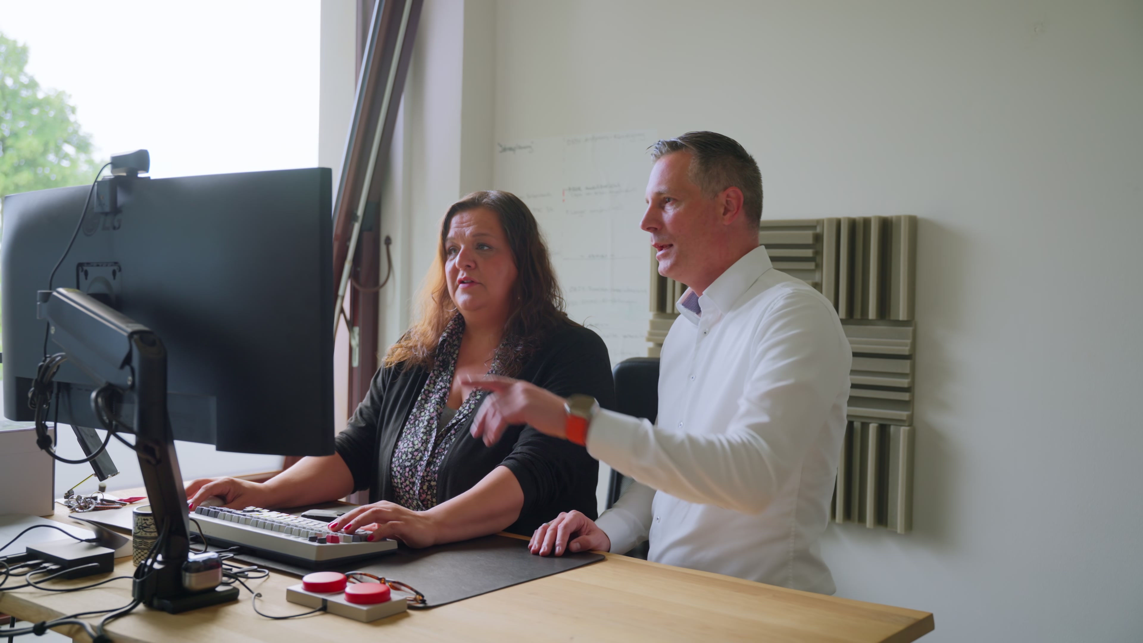 Berater und Mitarbeiterin analysieren gemeinsam Daten am Monitor