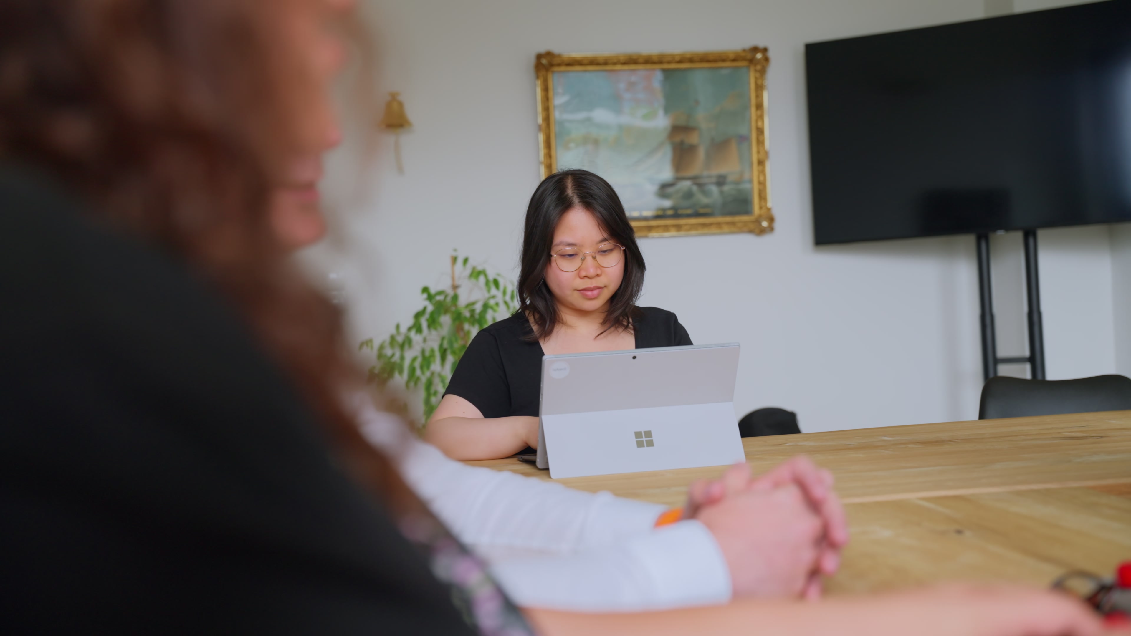 Mitarbeiterin arbeitet konzentriert am Tablet