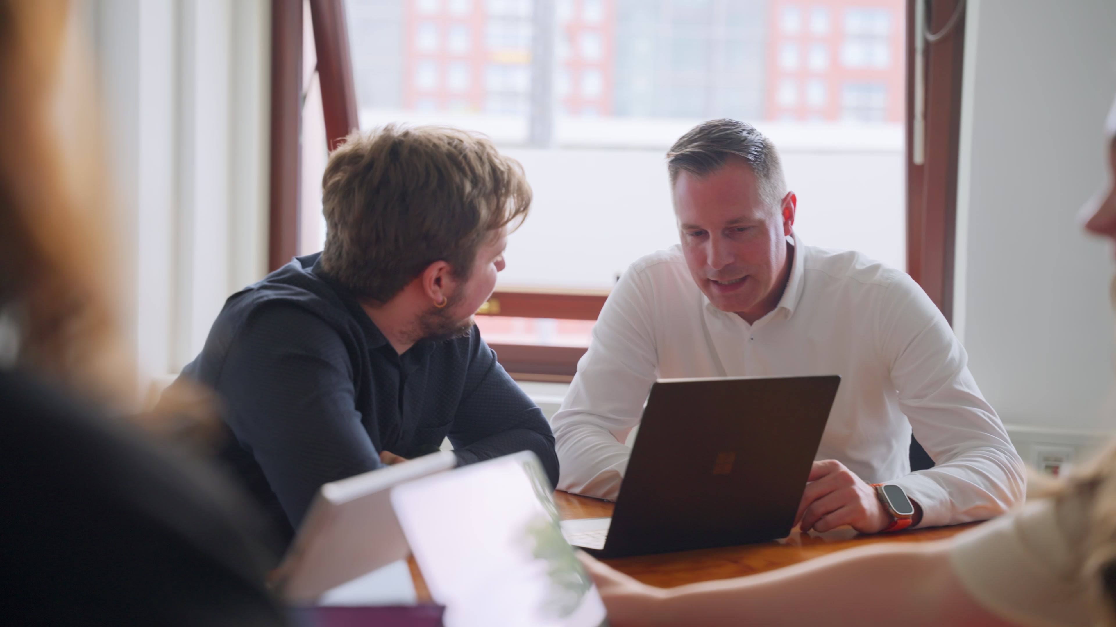 Berater und Mitarbeiter prüfen gemeinsam Finanzdaten am Laptop