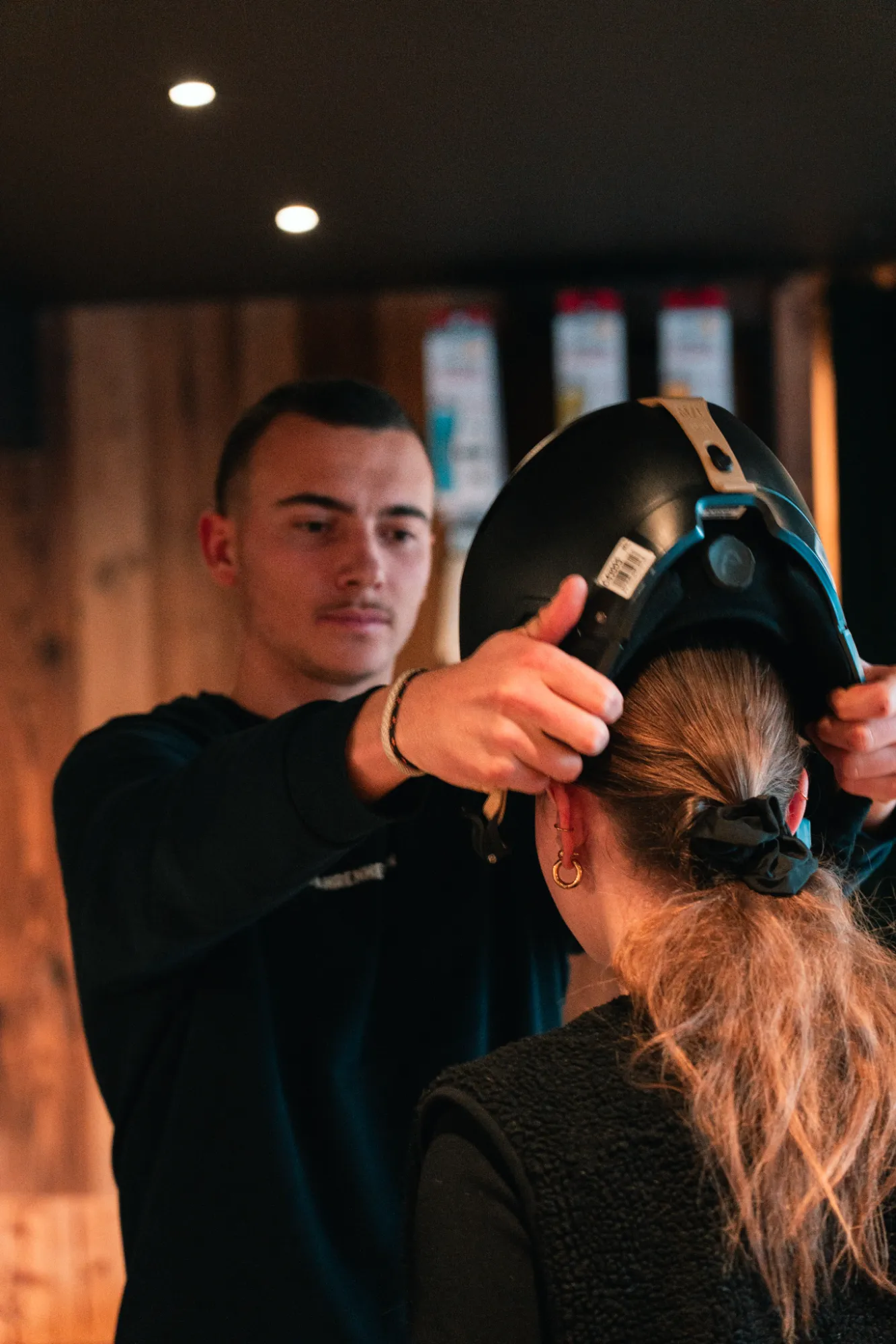Membre du personnel ajustant un casque pour un client, Ski Boutique °F7 Courchevel