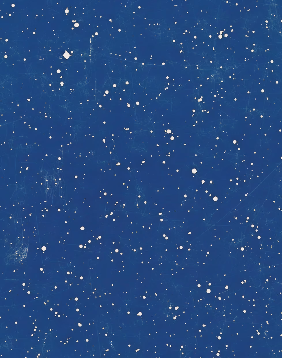 Blue background with scattered white spots resembling paint splatters or stars.