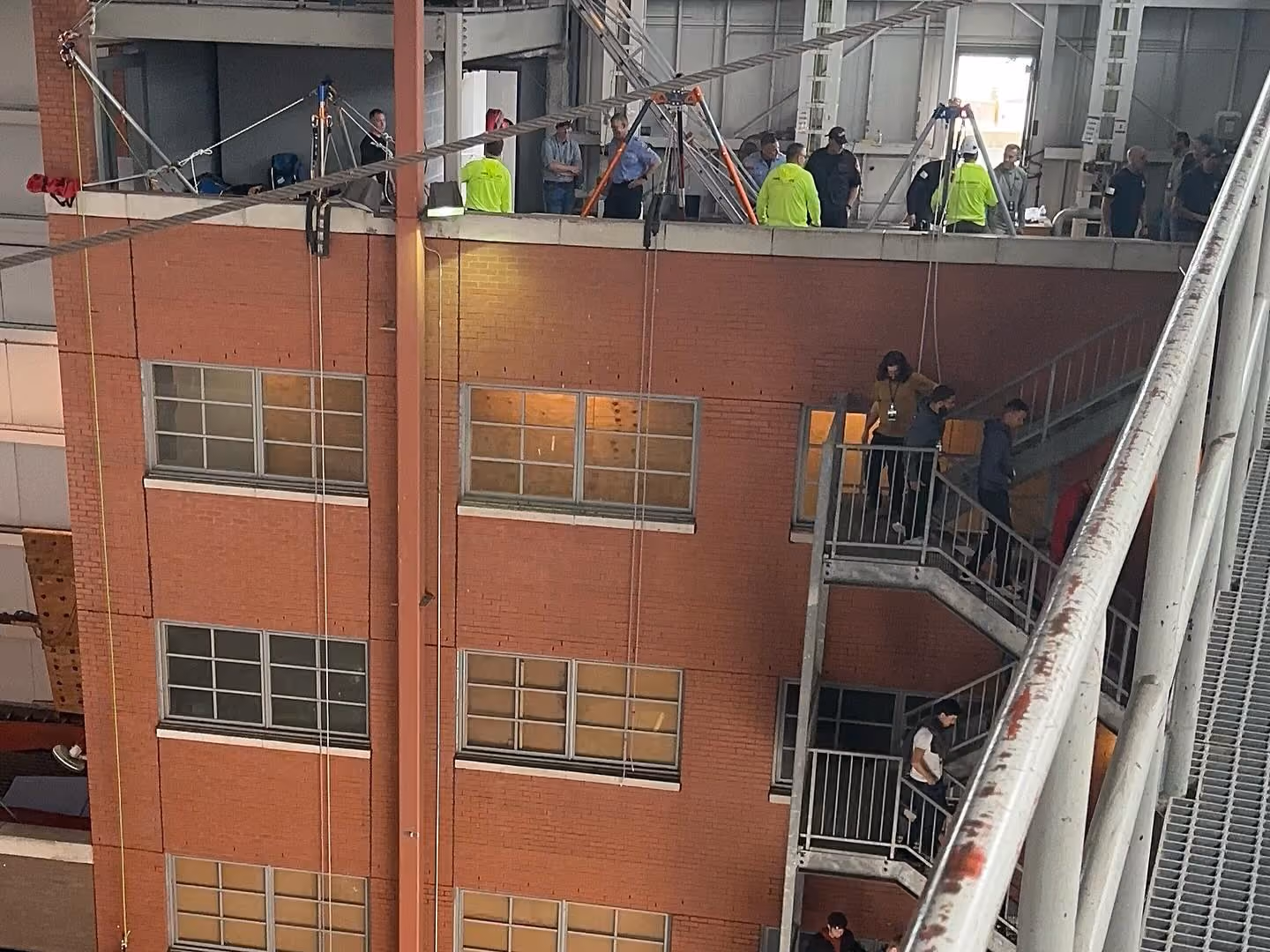 Crews rigging from the roof edge of a brick building during a Training Day