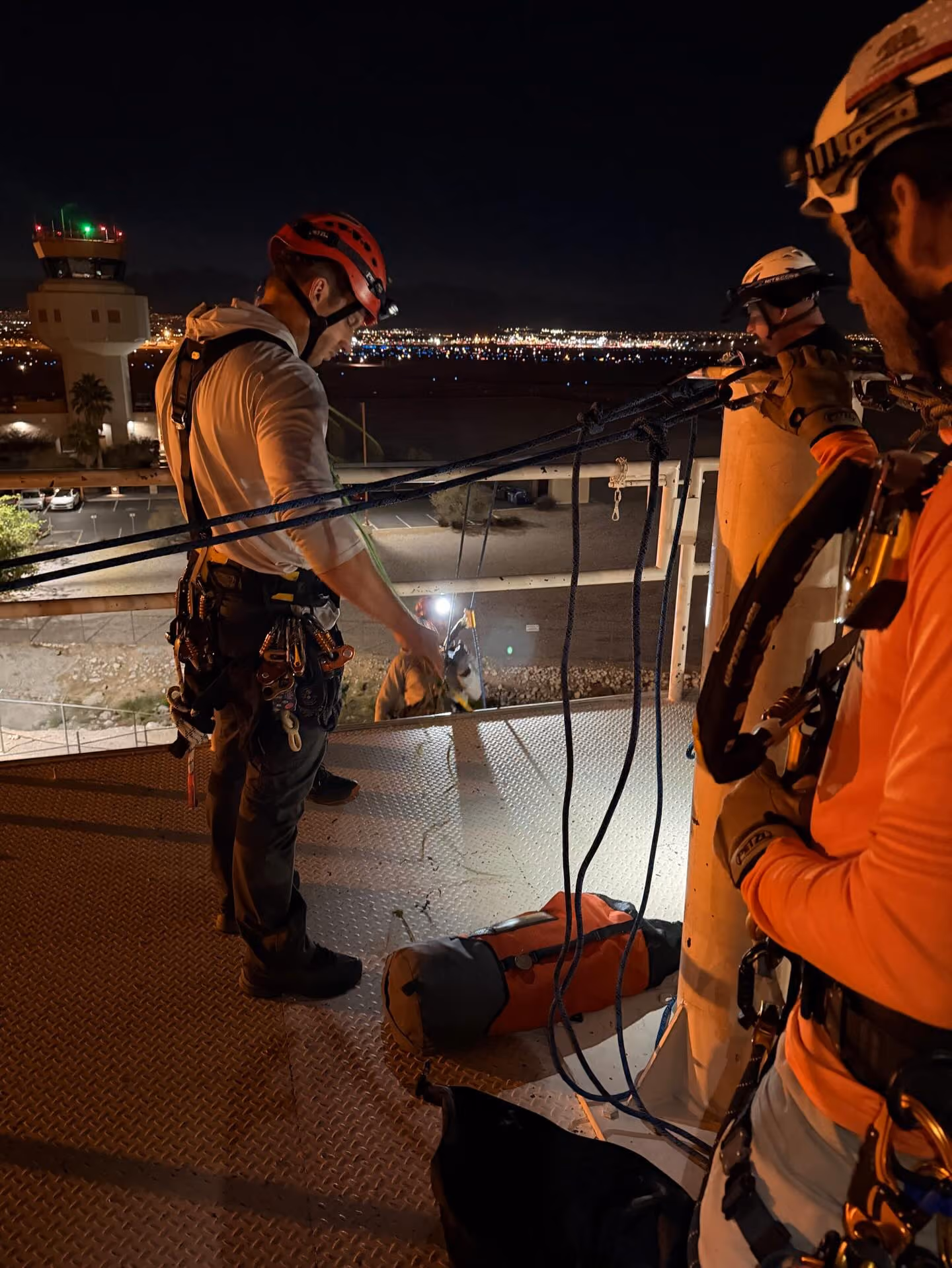 Night rope work on a rooftop edge