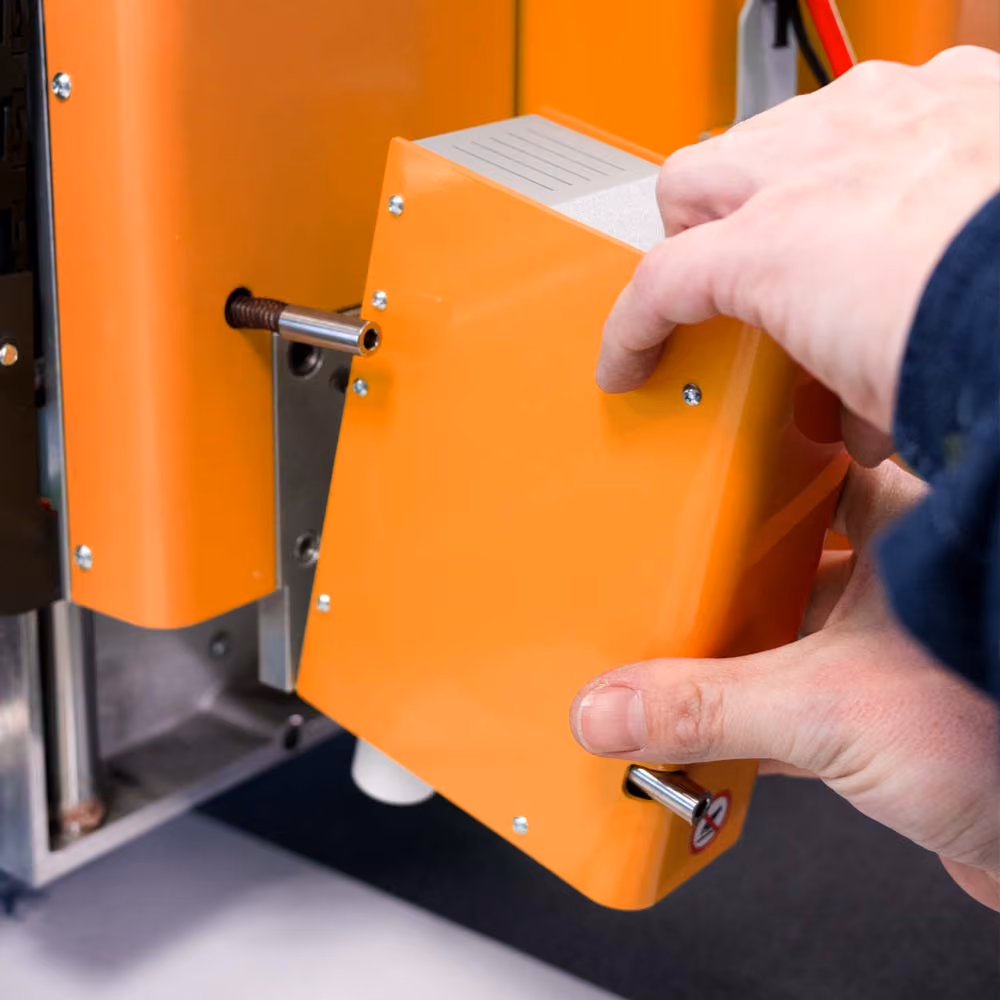 Operator installing a new tool on a Kongsberg C toolhead