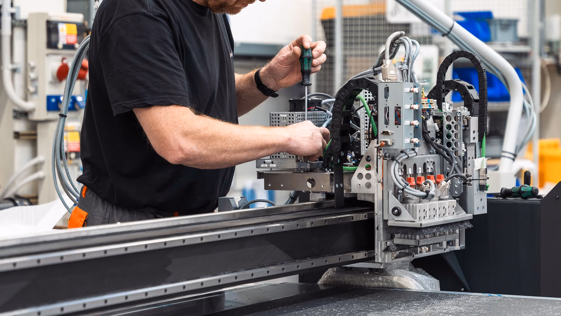A Kongsberg technician working on the internal electronics of a Kongsberg C toolhead