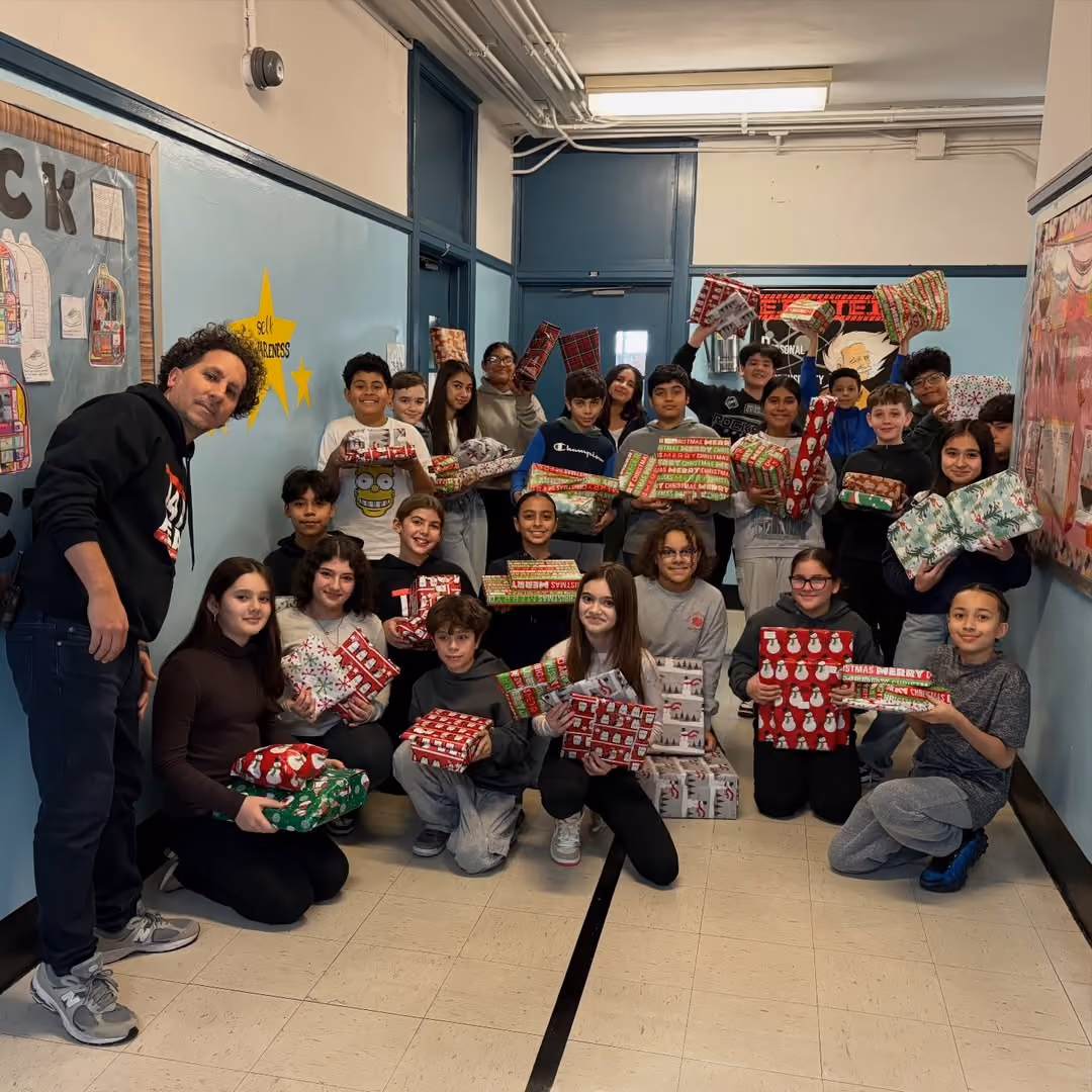 Students holding wrapped gifts collected for the AEA Snowflake Drive