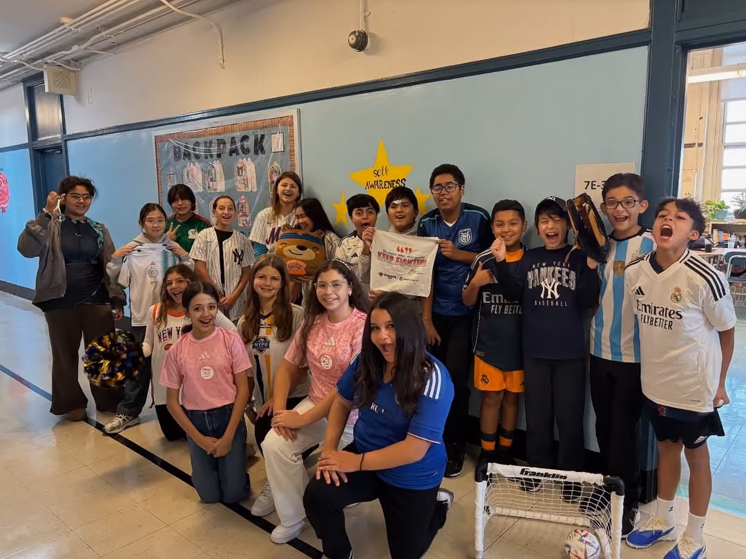 Students in sports jerseys posing together on Spirit Day